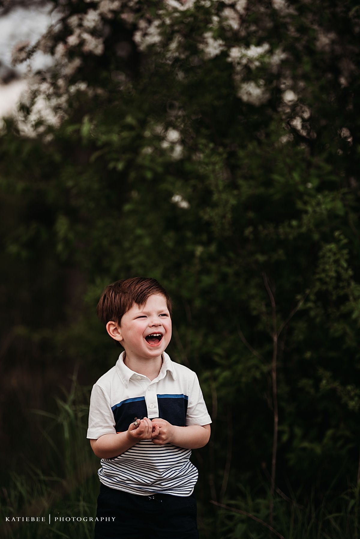 A candid shot captures pure joy and laughter in a natural outdoor setting.
