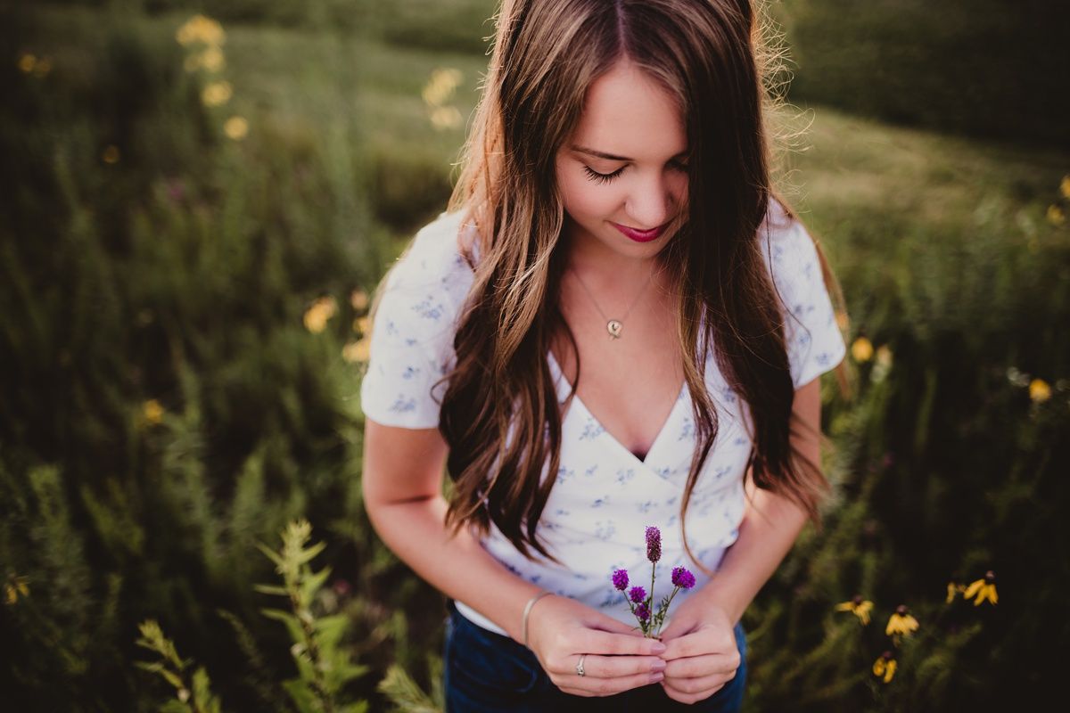 A peaceful moment in a meadow with yellow flowers and a white-clad figure looking down.