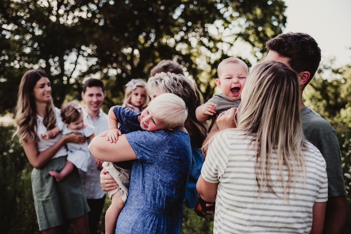 Candid family gathering moment captured outdoors during sunset.