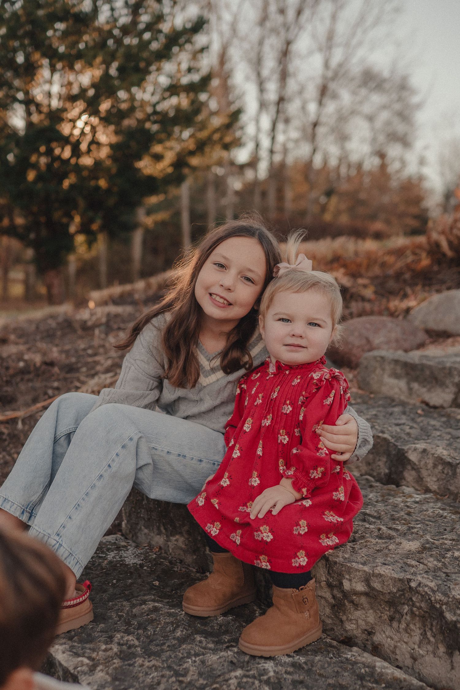 Two people sharing a playful moment on rocky terrain during golden hour.