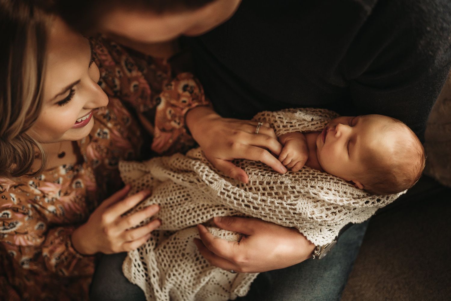 An intimate moment with a newborn baby wrapped in delicate knit fabric.