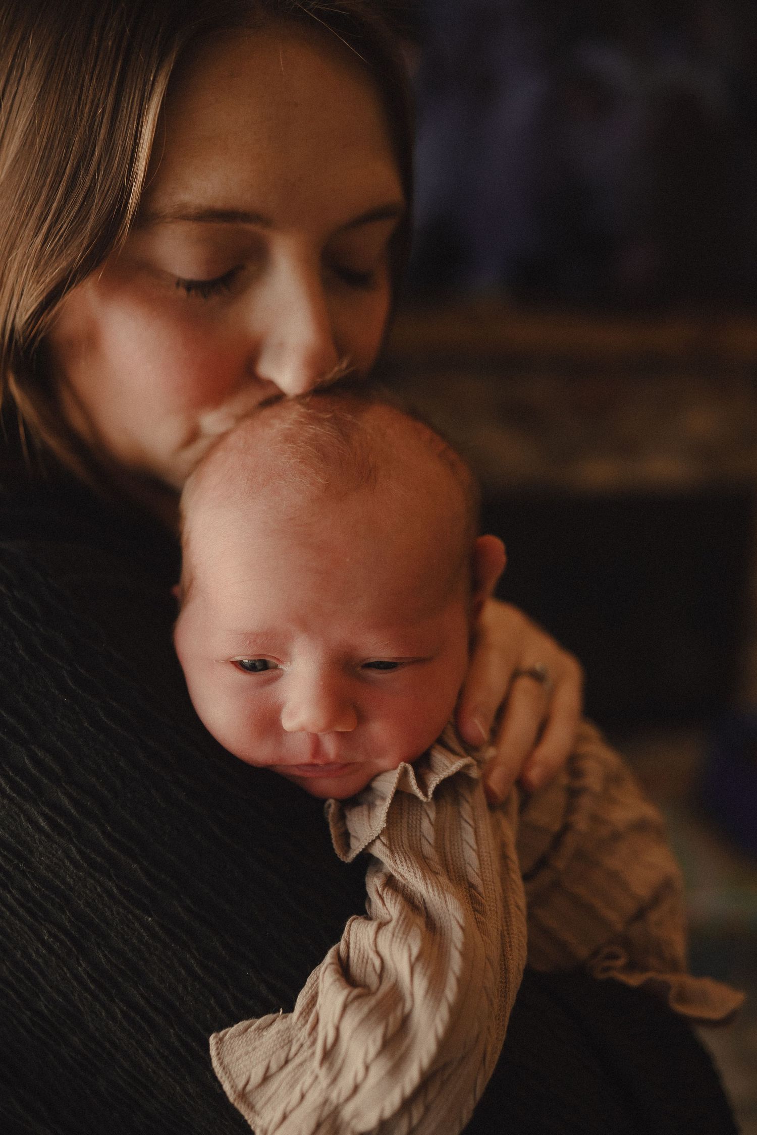 Artistic close-up shots showing gentle kisses in warm, moody lighting.