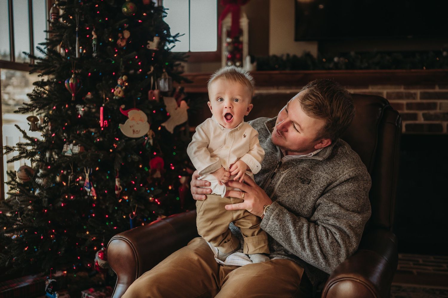 Heartwarming holiday scene in front of Christmas tree with brick wall background.