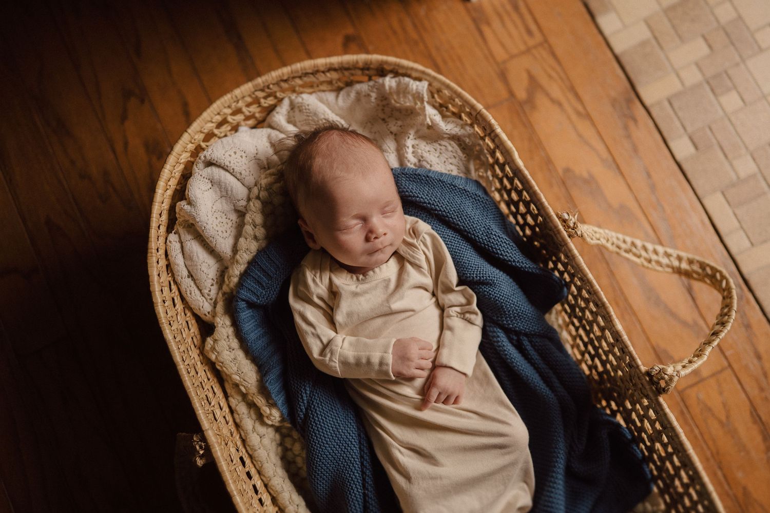 Peaceful domestic scenes with a woven bassinet on hardwood floors in natural light.