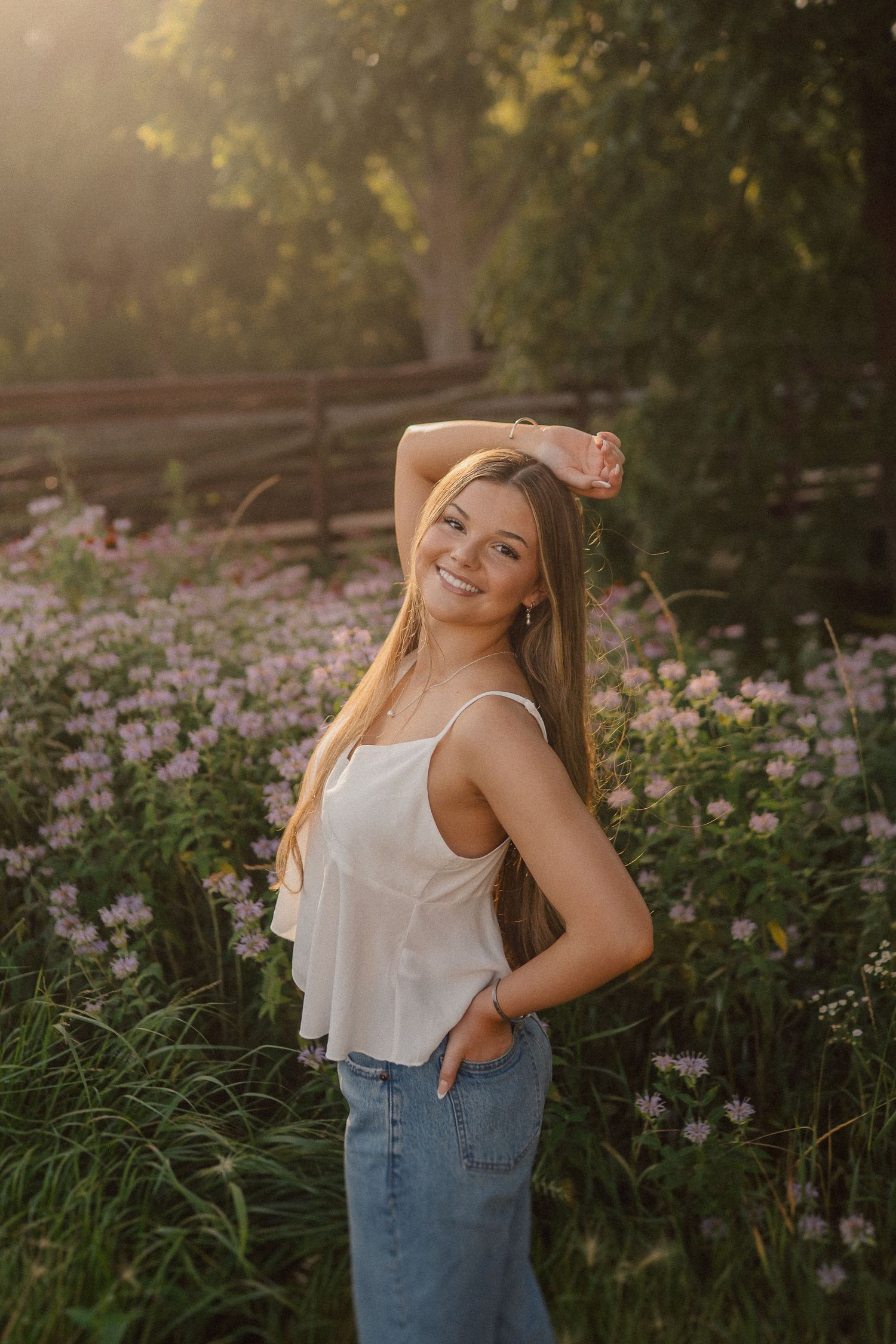 A candid summer portrait in a wildflower meadow at golden hour with soft natural lighting.