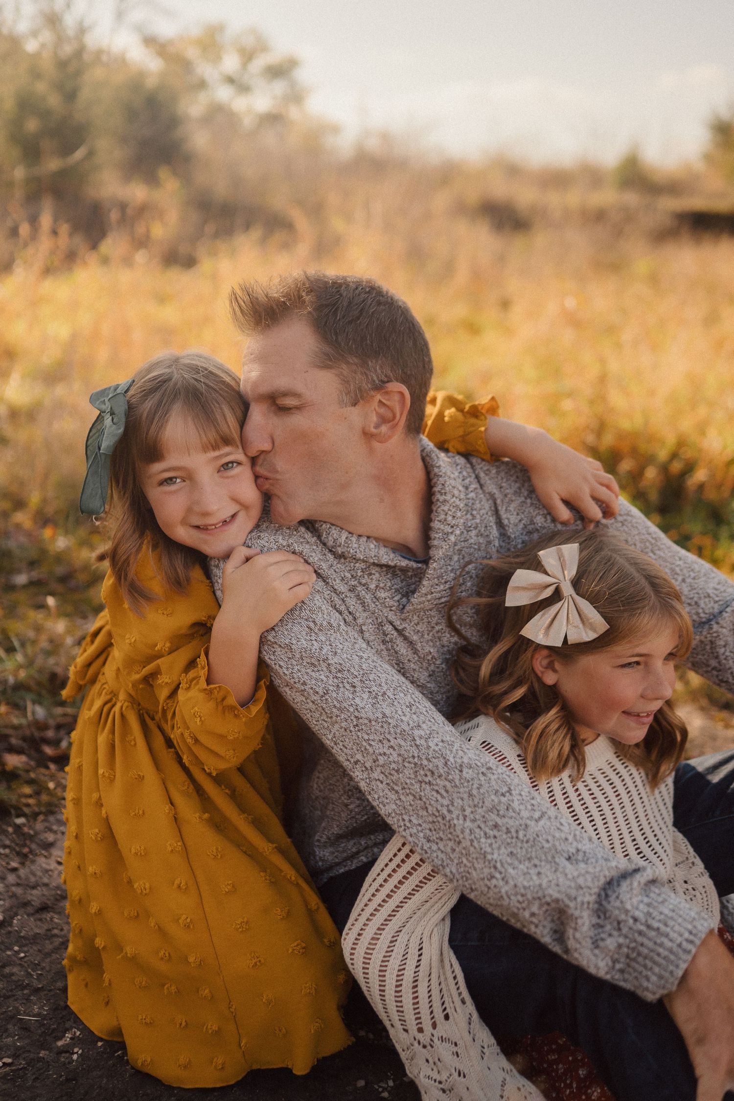 A sweet family moment captured outdoors with cozy sweaters and warm autumn colors.