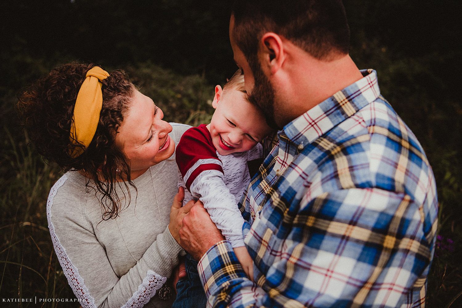 Family laughing together in outdoor portrait session.