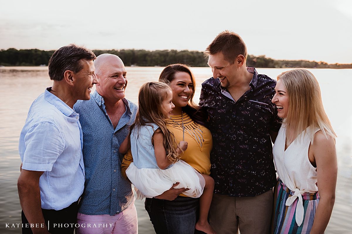 A group enjoying a sunset gathering by the water on a warm evening.