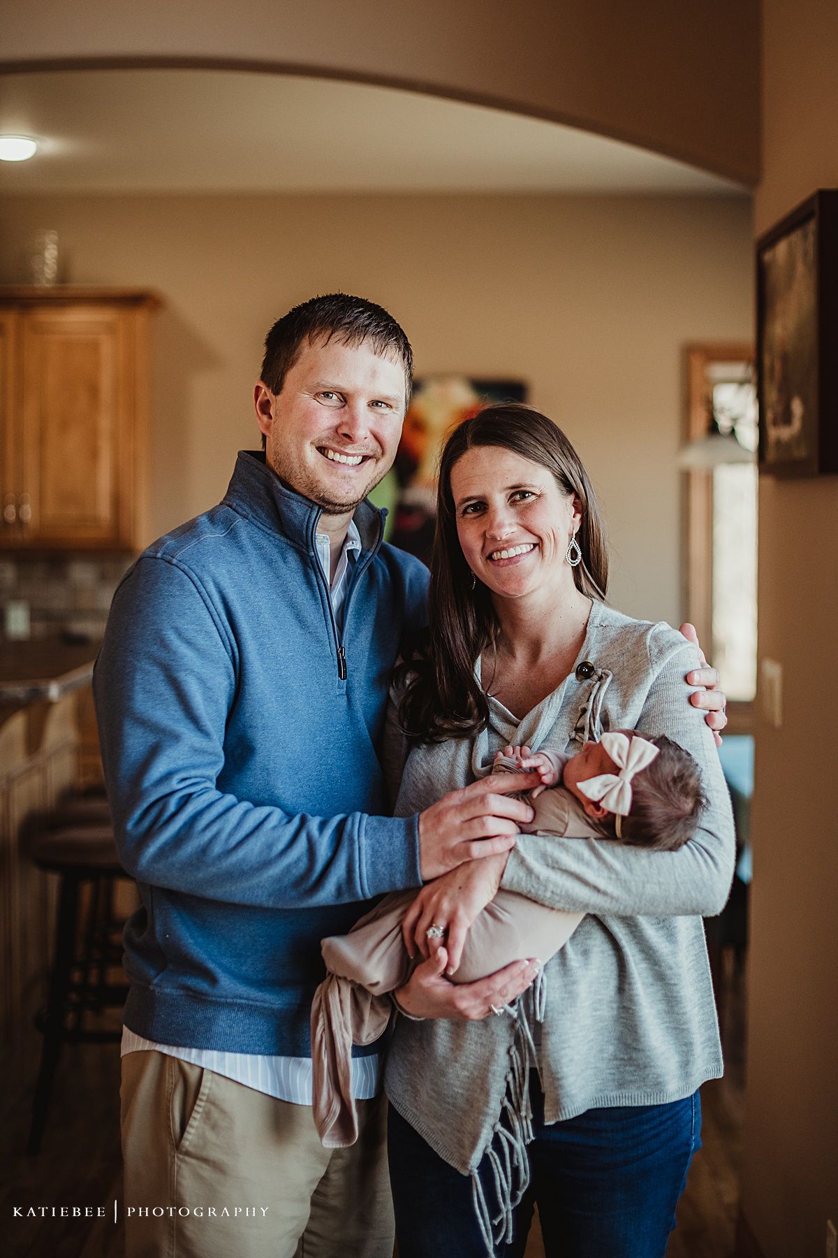 Family posing in kitchen during casual lifestyle photography session.