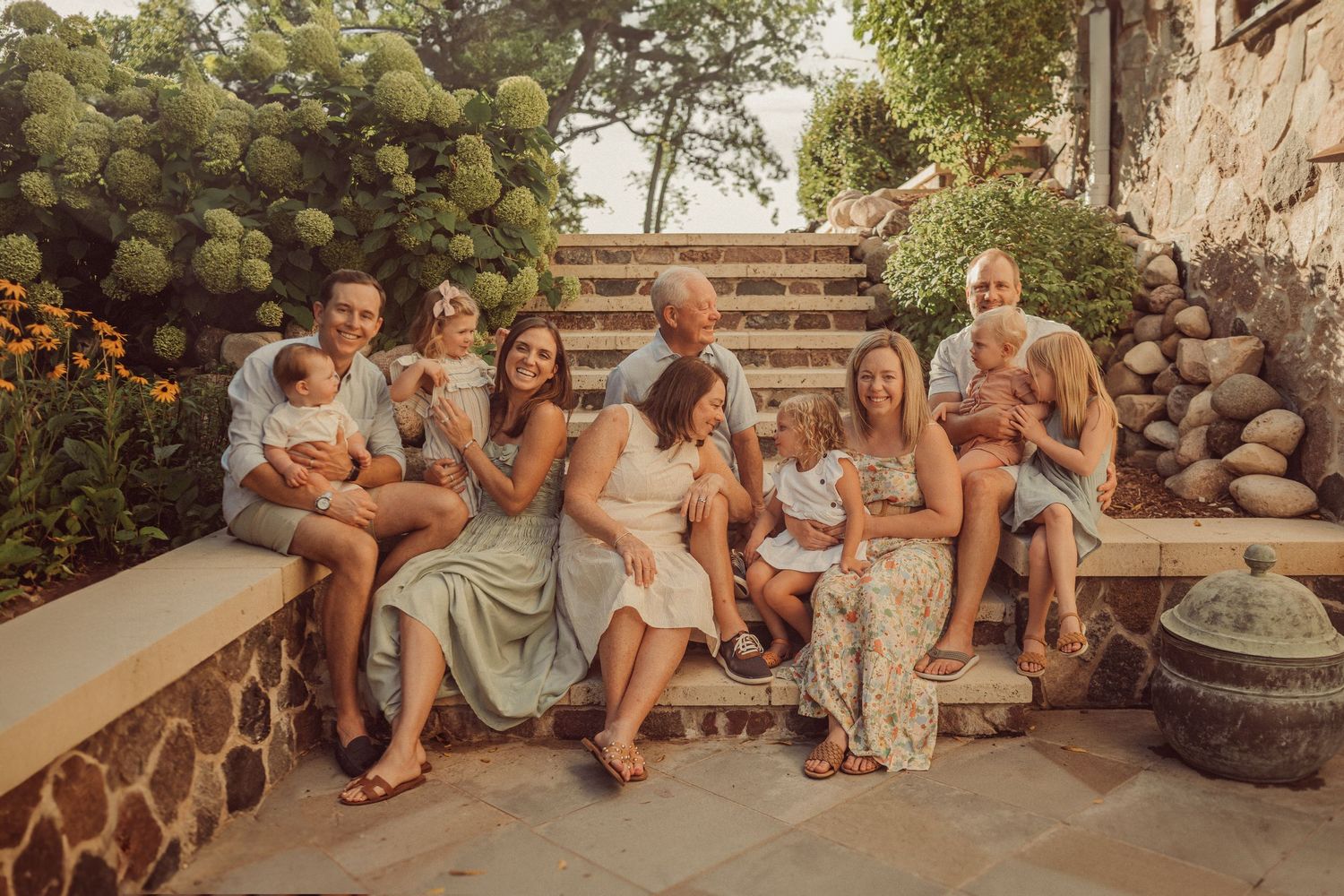 Group of people sitting together on stone steps during golden hour.