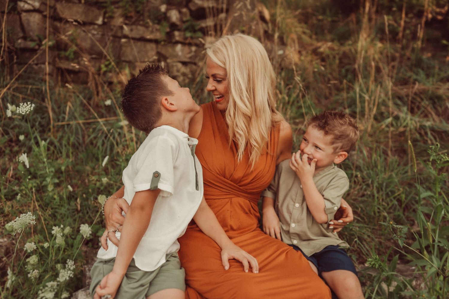 A joyful family shares laughs while sitting together outdoors in summer.