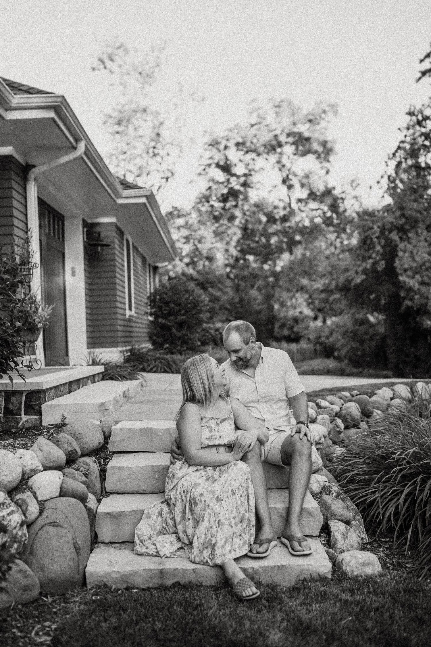 Black and white photo of two people sharing an intimate moment on stone steps.