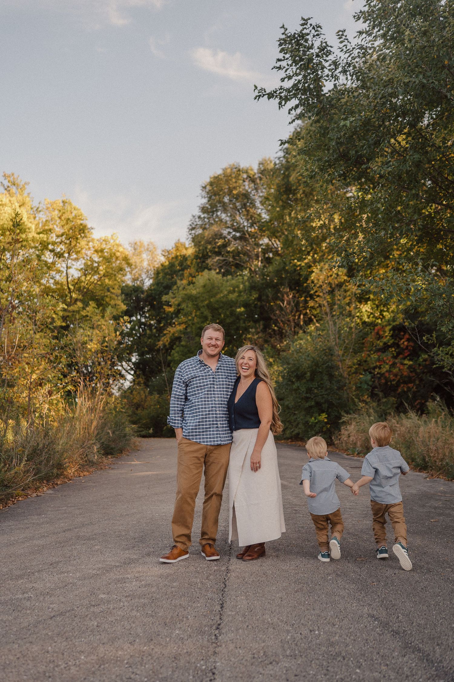 A family poses together on a nature trail during golden hour.