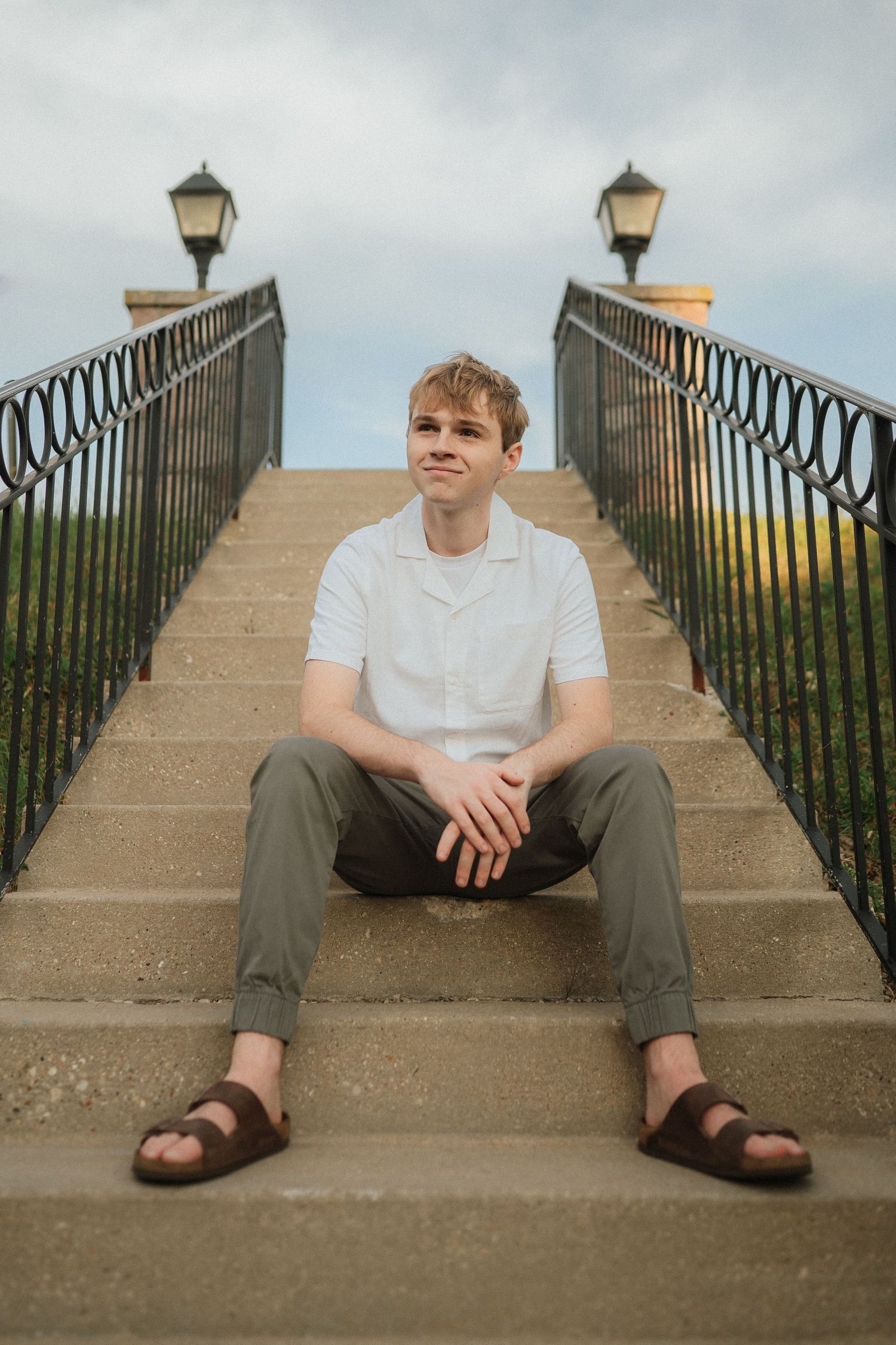 A series of photos showing someone sitting on concrete steps with decorative metal railings at sunset.