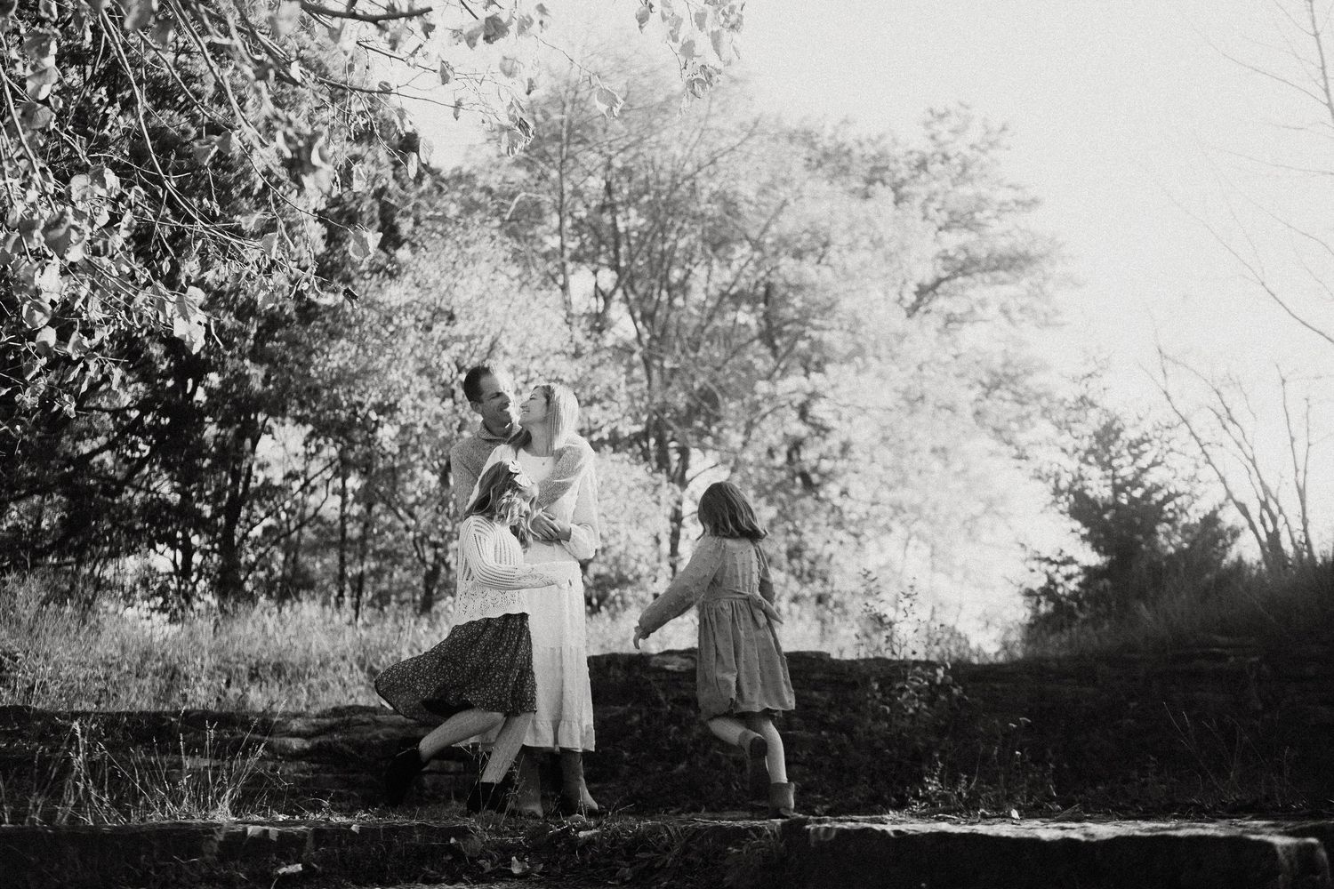 Two figures dance together in a garden setting in this vintage black and white photograph.