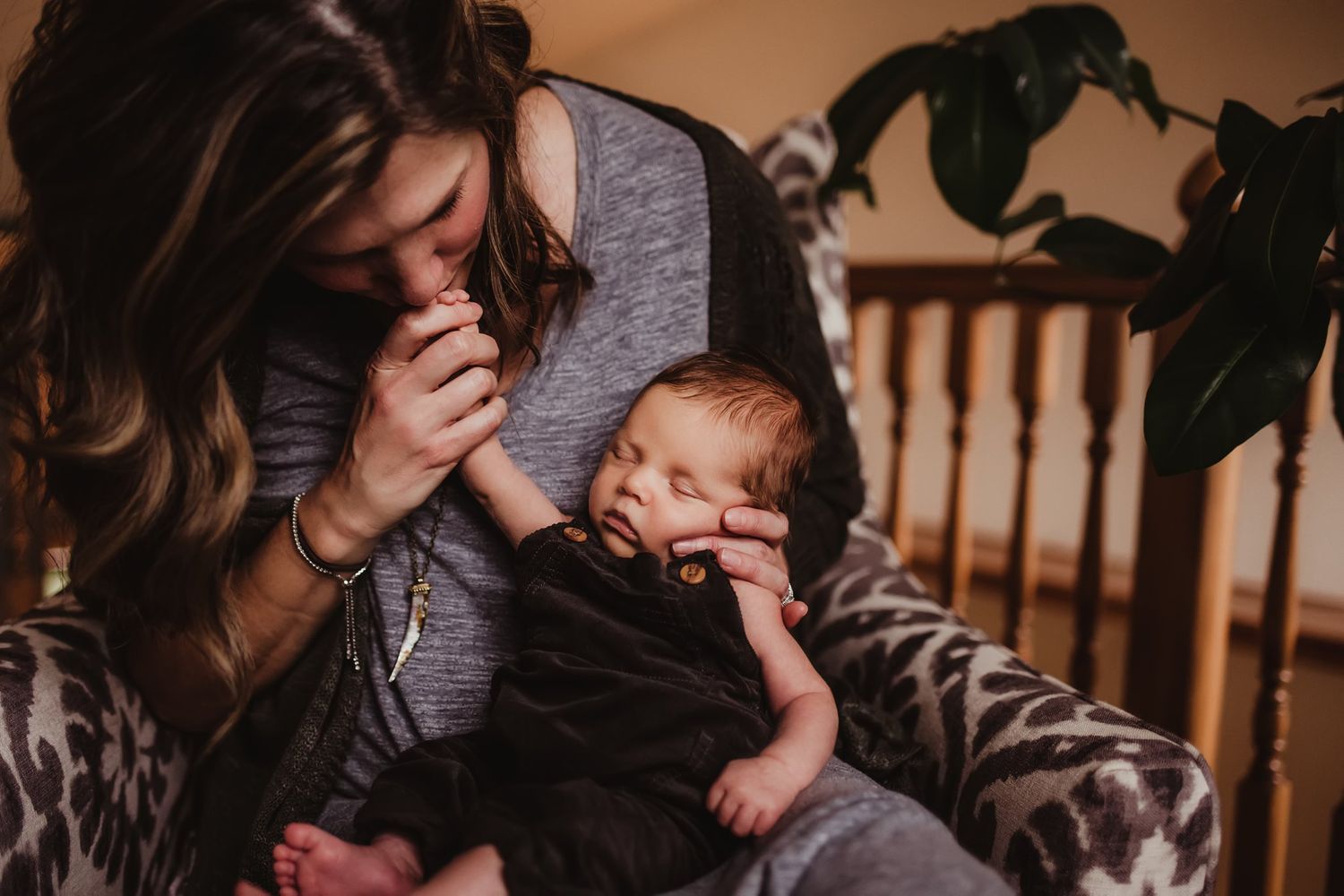 An artistic portrait captures a tender parenting moment on a patterned chair.