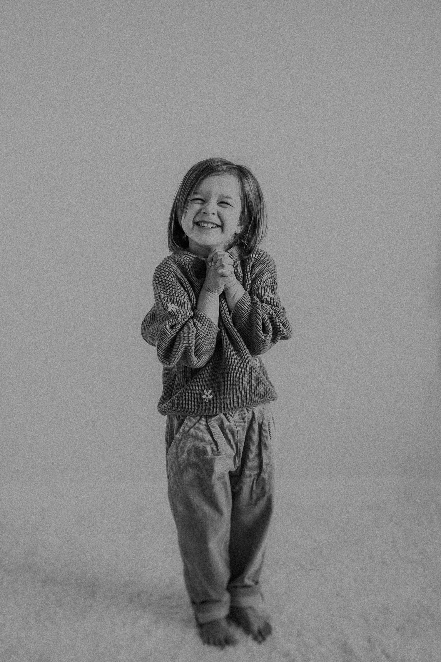 Sweet black and white portrait showing clasped hands and genuine happiness.