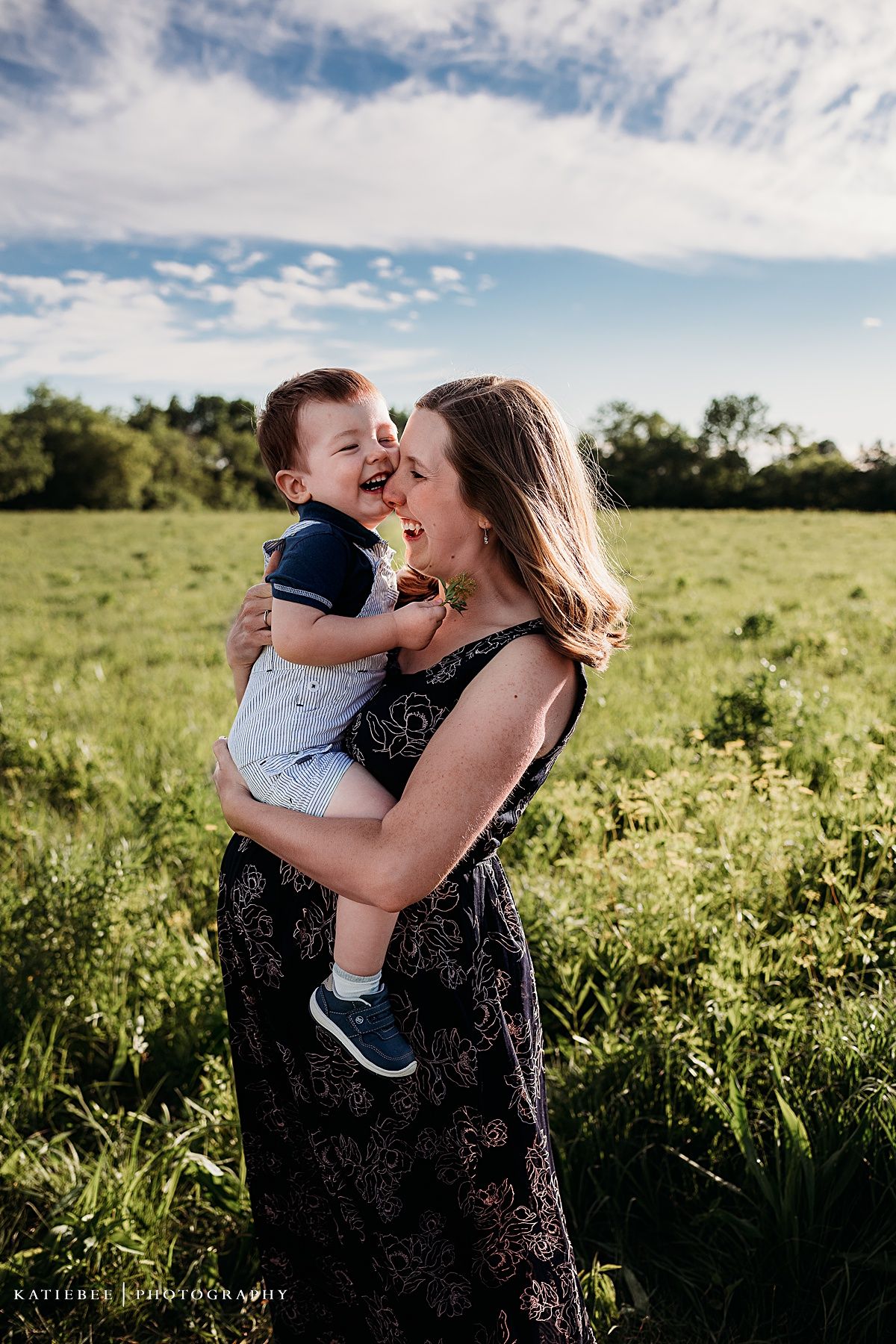 Candid moment of joy and laughter in a sunlit meadow during summer.