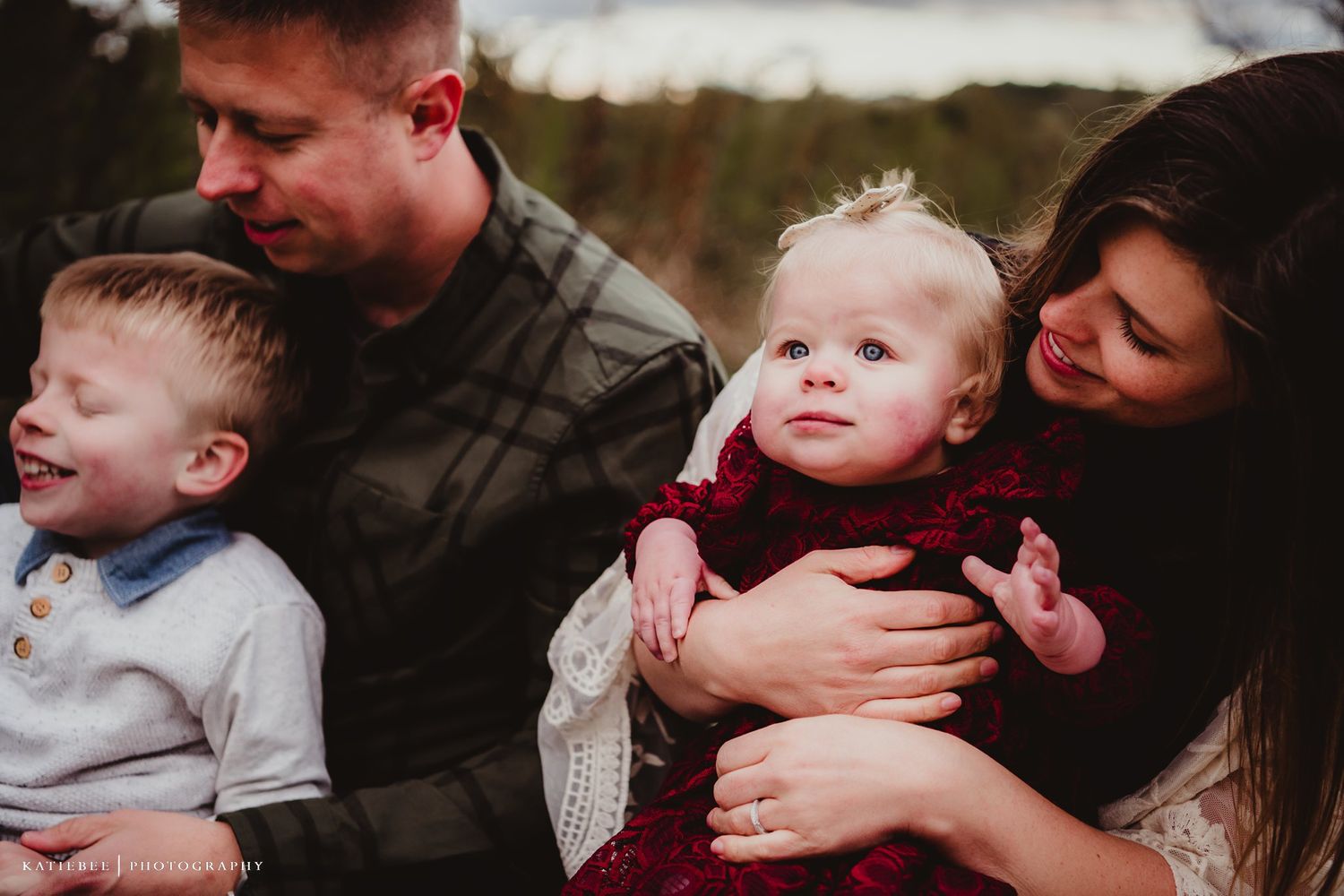 Intimate family moment captured outdoors with natural lighting and casual poses.
