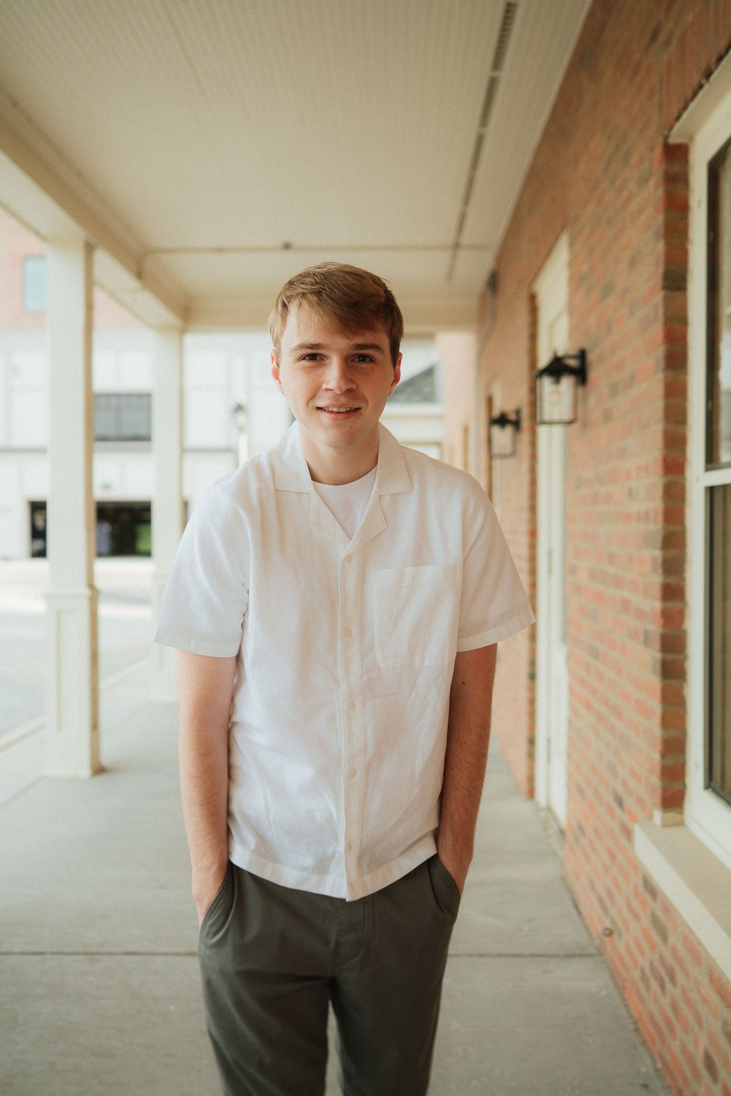 A series of four candid portrait photos taken in a brick hallway with natural lighting.