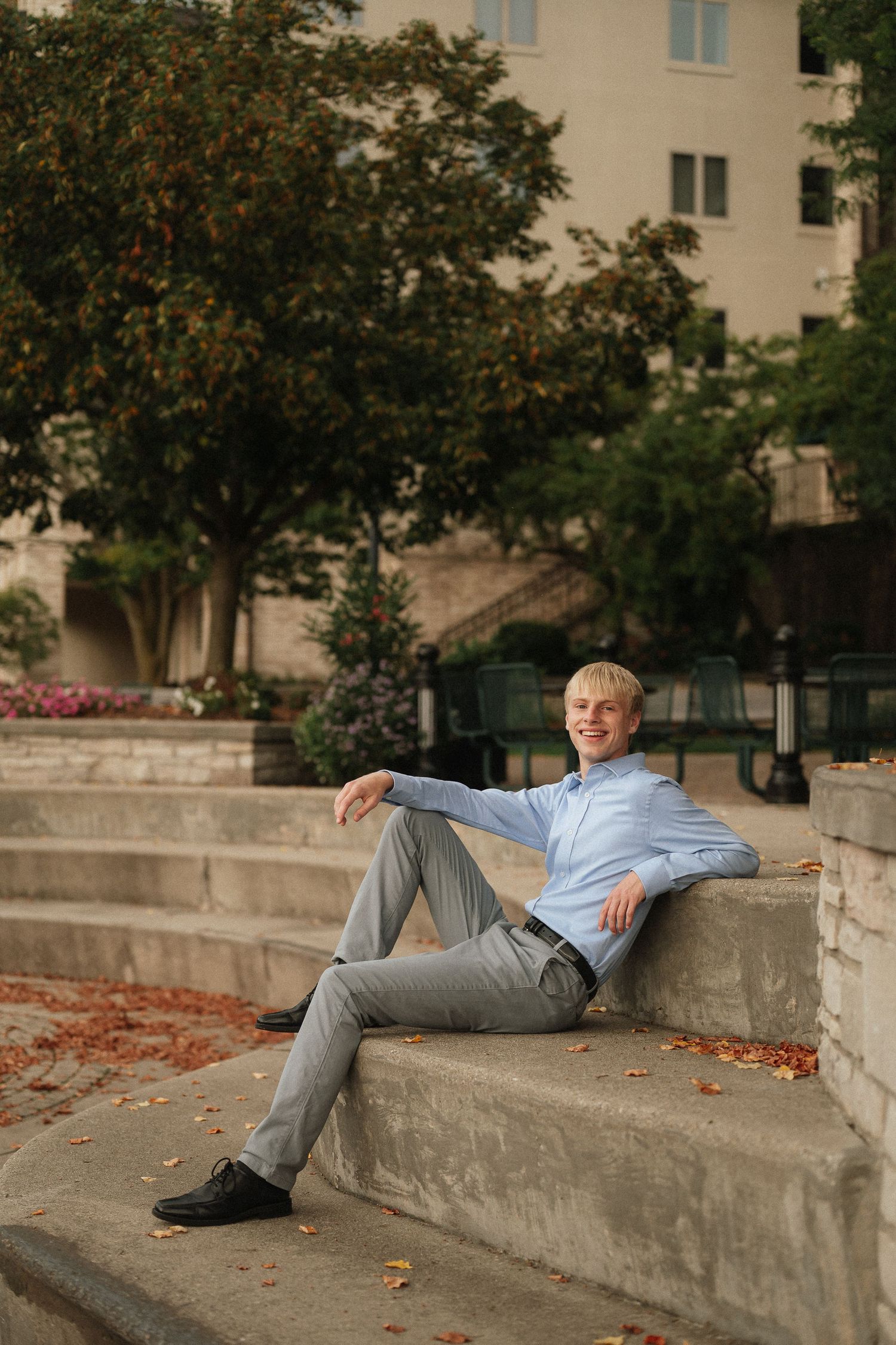 A series of casual poses on concrete steps showing different relaxed positions with autumn leaves in the background.