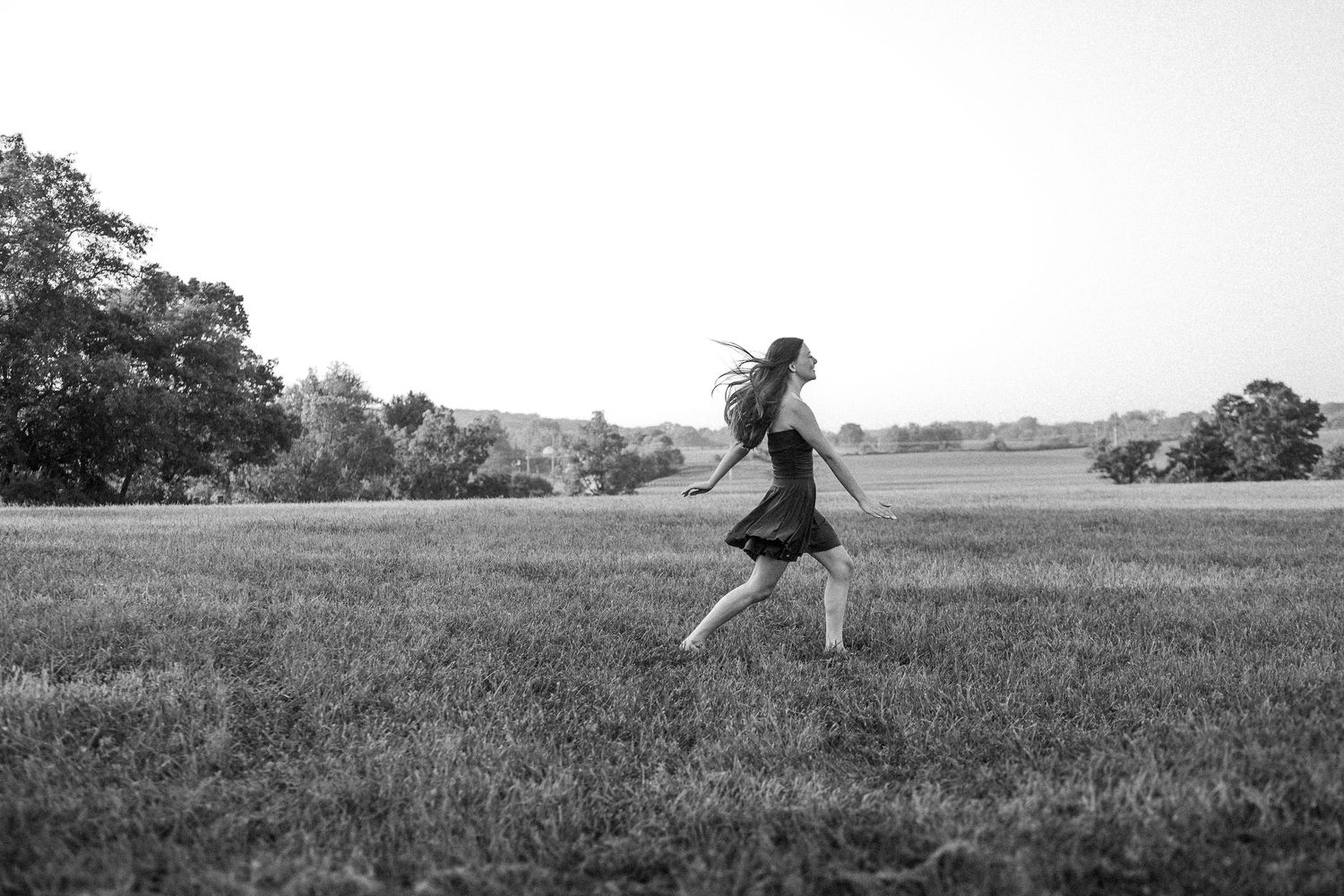 A sequence of black and white photographs shows a person with umbrella walking through an empty field.