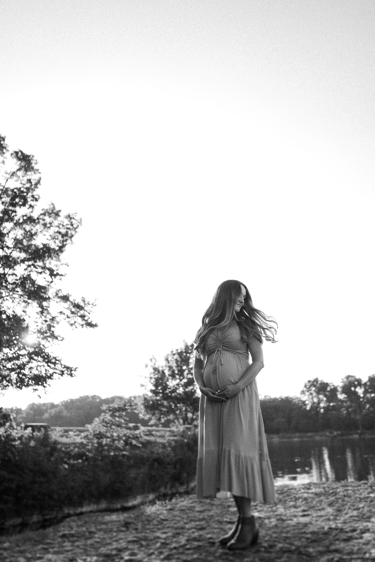 A silhouetted figure stands in a scenic outdoor setting against a bright white background.