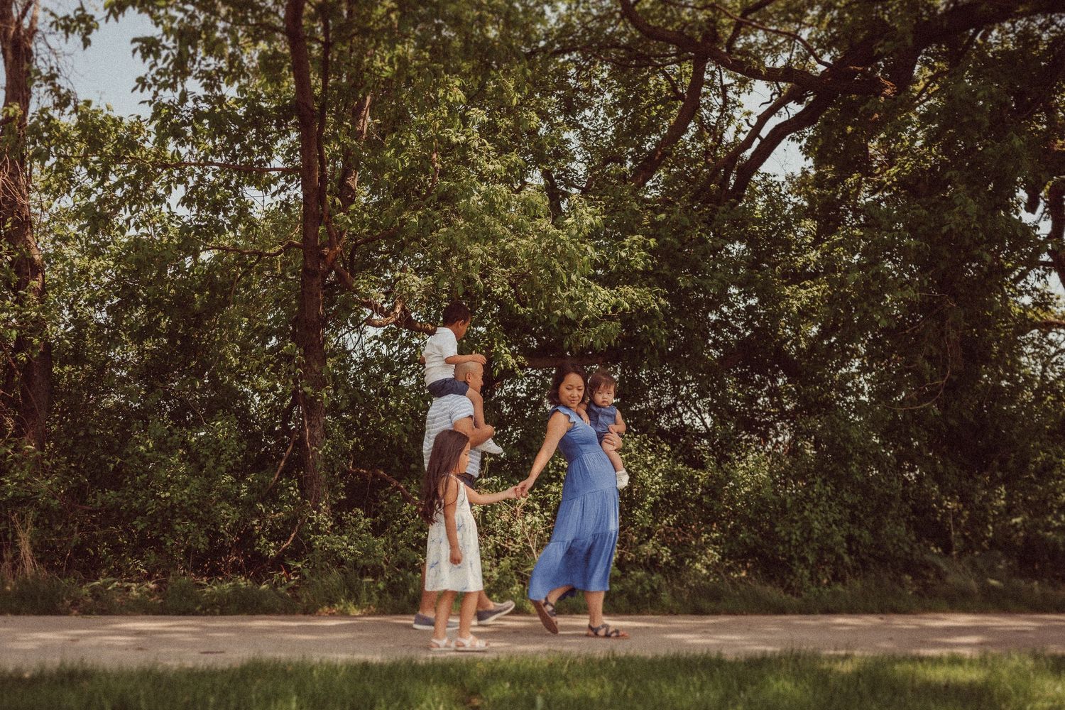 A group enjoys a playful moment together on a wooded walking trail.