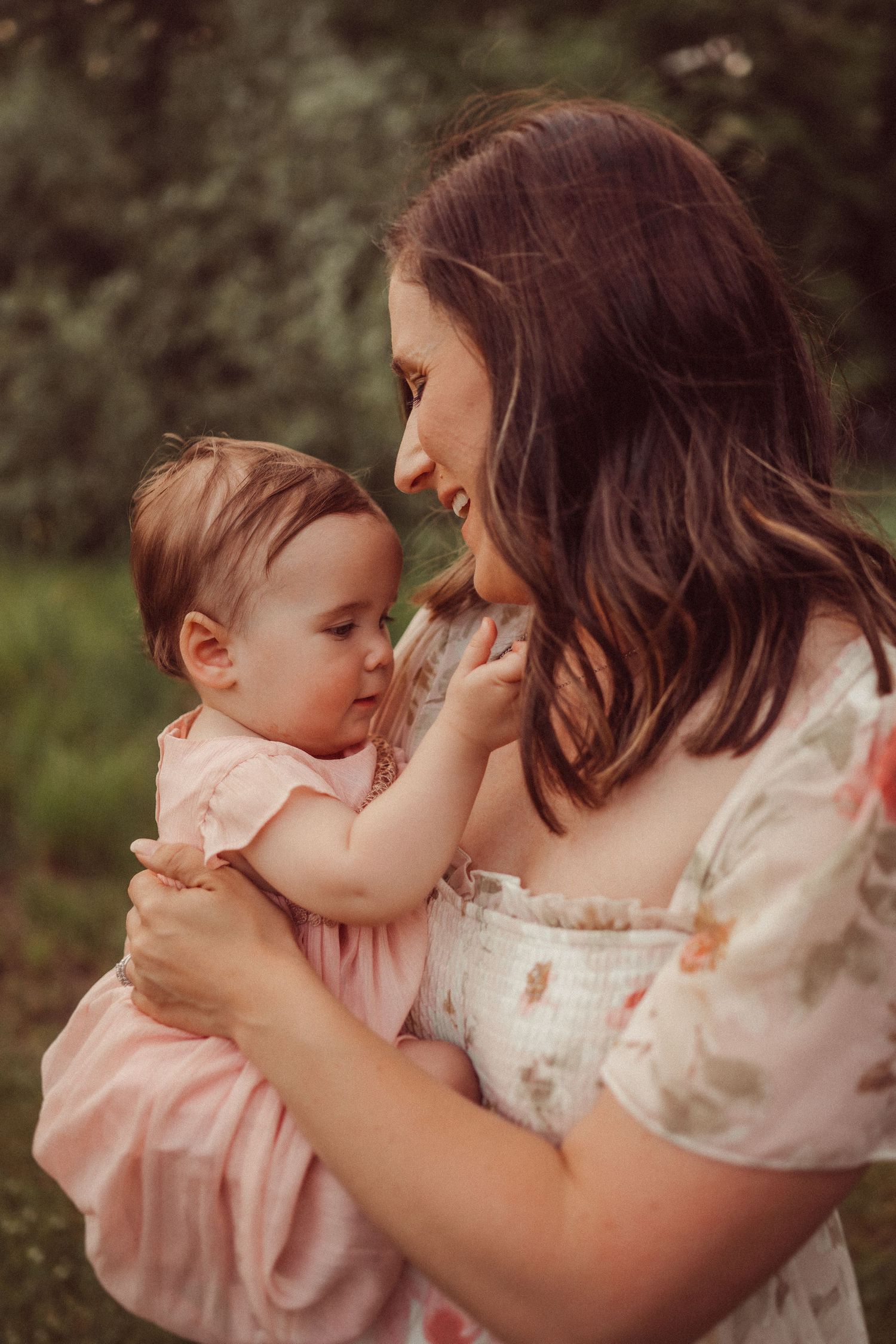A tender moment between parent and child in soft natural lighting outdoors.