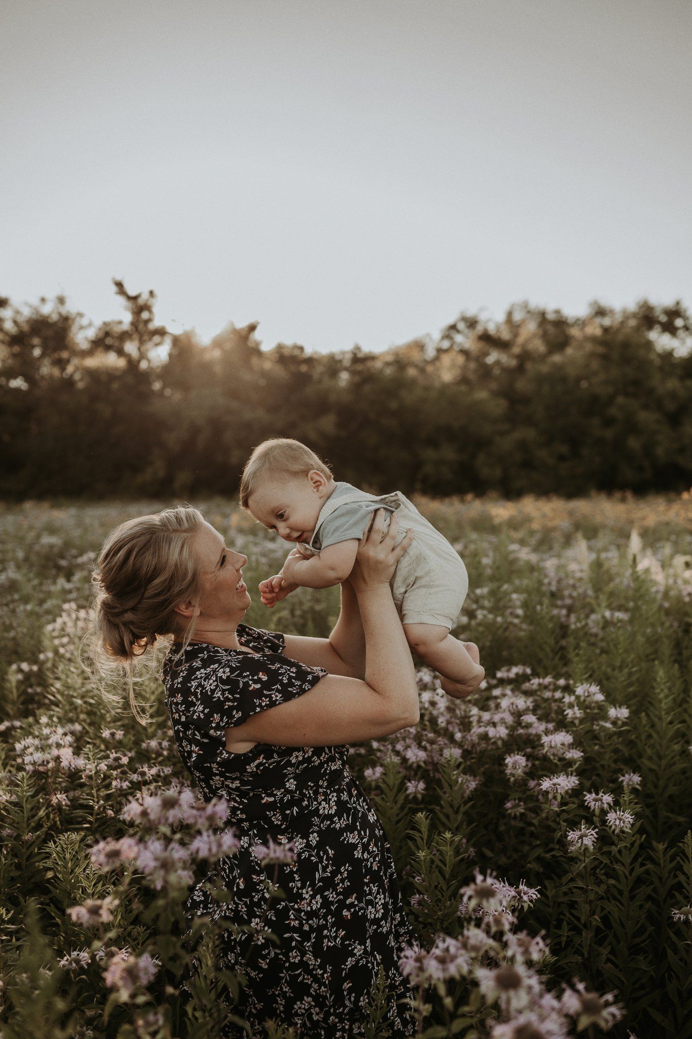 Tender moment in wildflower field during sunset family photoshoot.