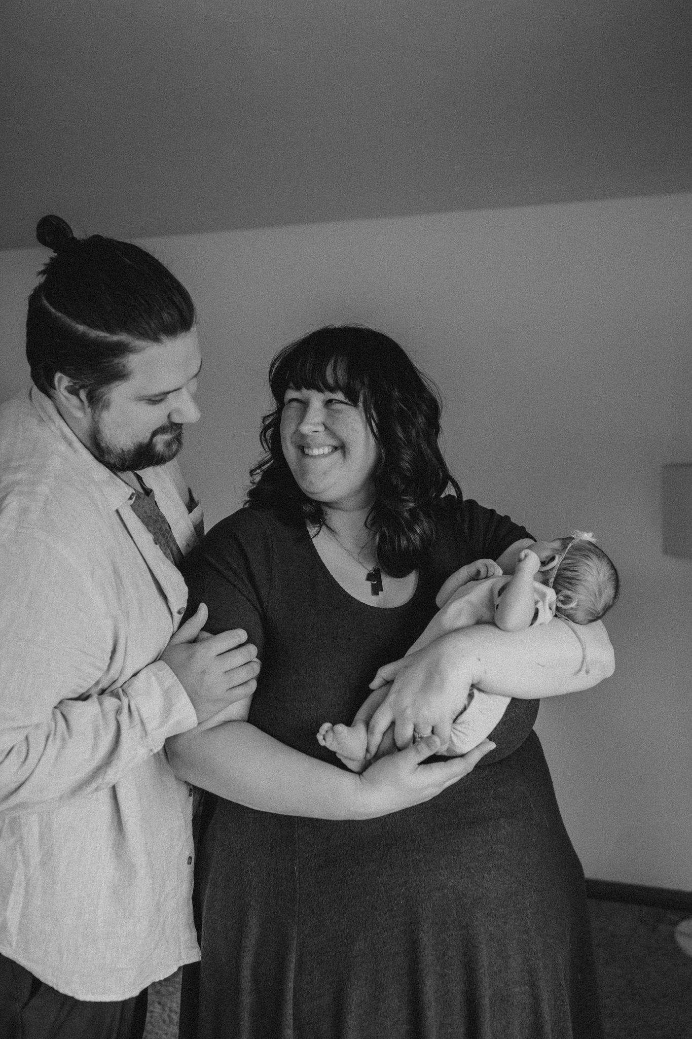 Black and white portrait of happy moment with newborn during photography session.