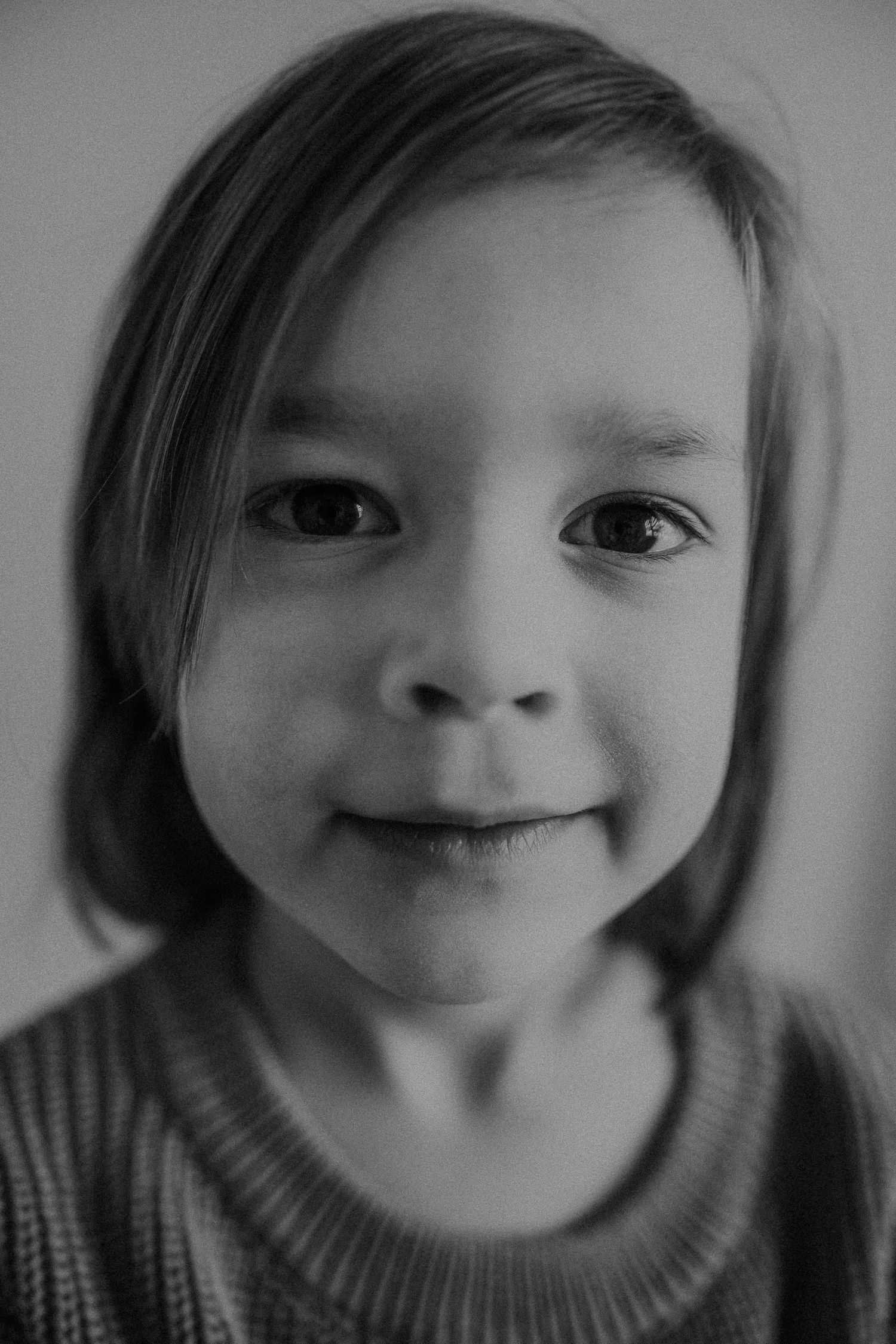 Intimate black and white close-up portrait showing gentle smile.