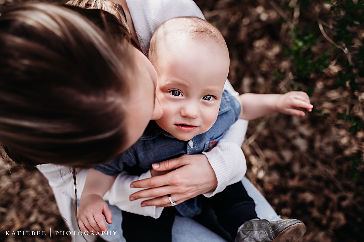 Close up of tender moment between parent and baby outdoors.