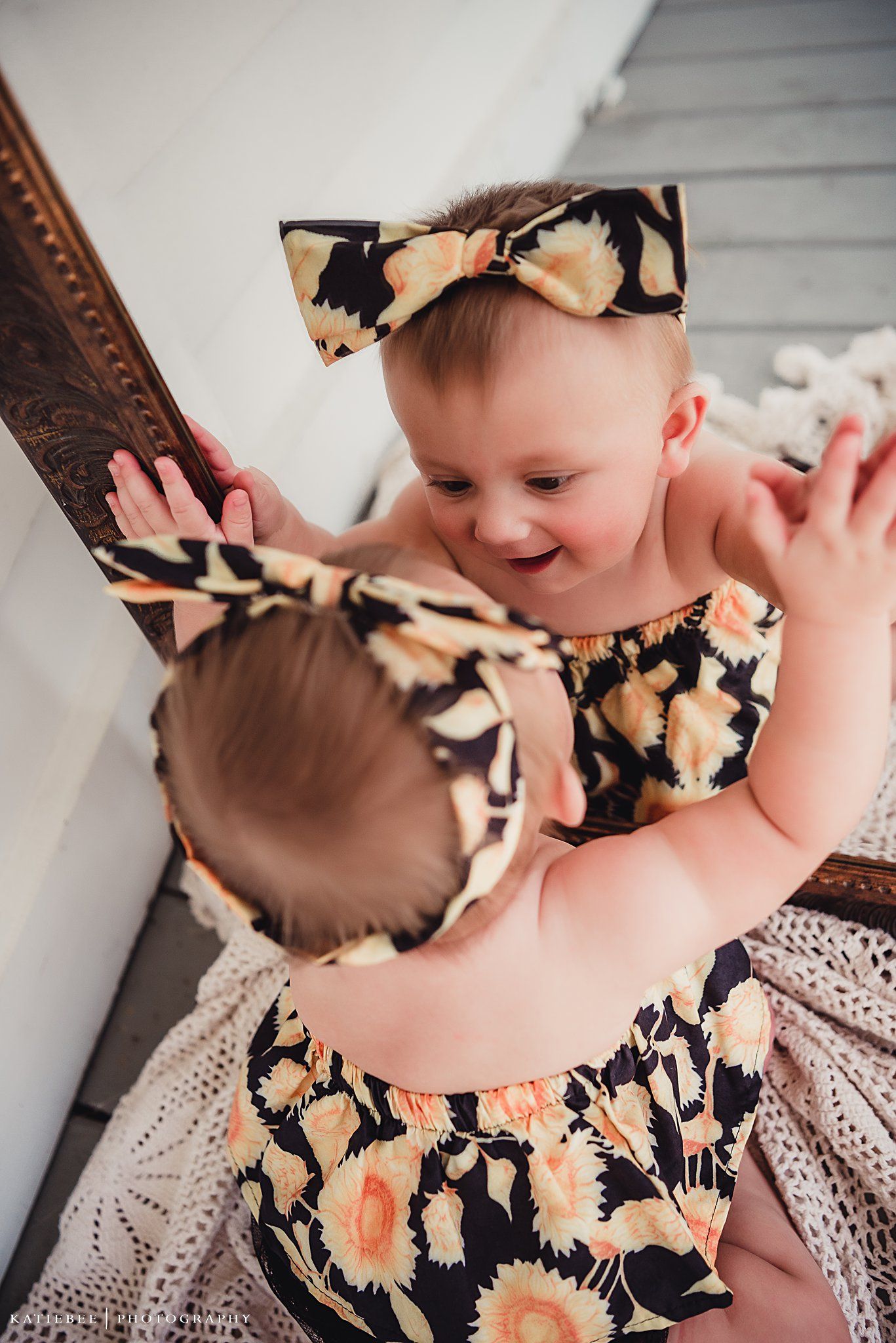 Floral print outfit reflecting in ornate mirror with decorative frame.