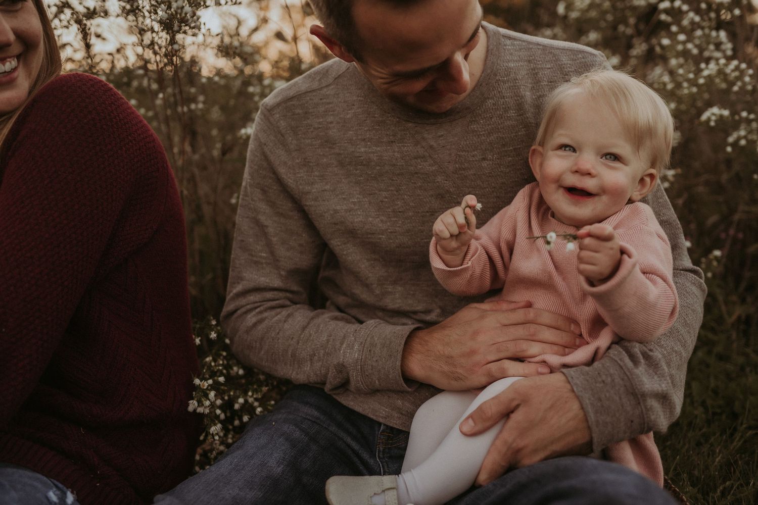 Close-up candid moment of joy and laughter during outdoor family photoshoot at sunset.