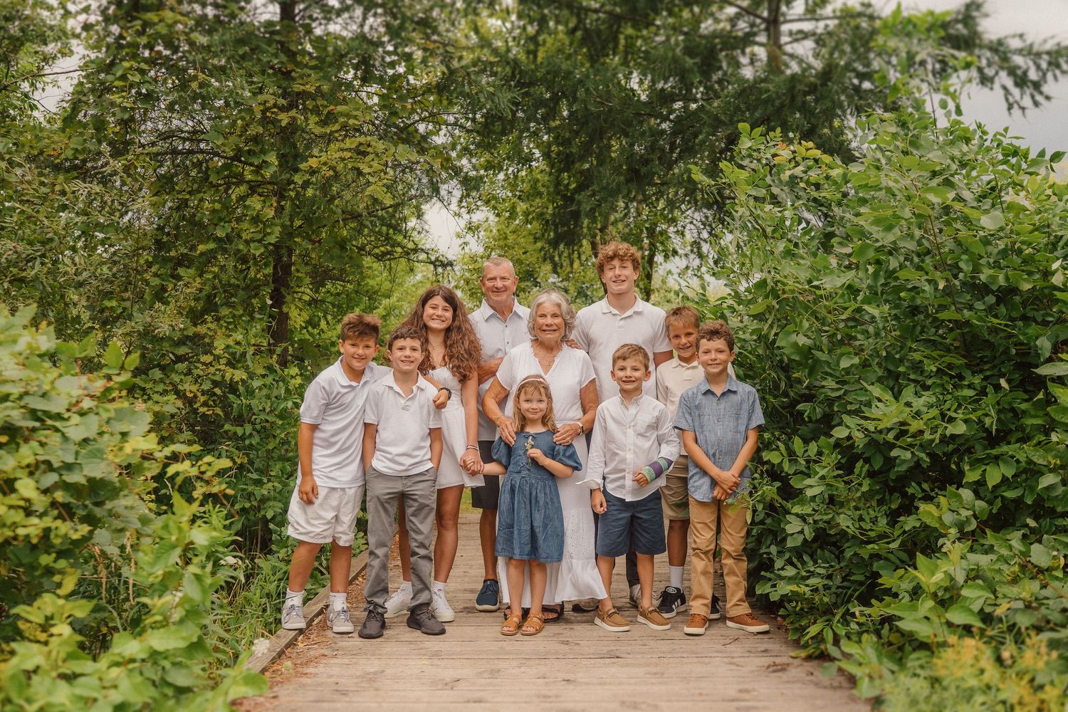 Extended family group photo session outdoors with coordinated white and blue outfits.