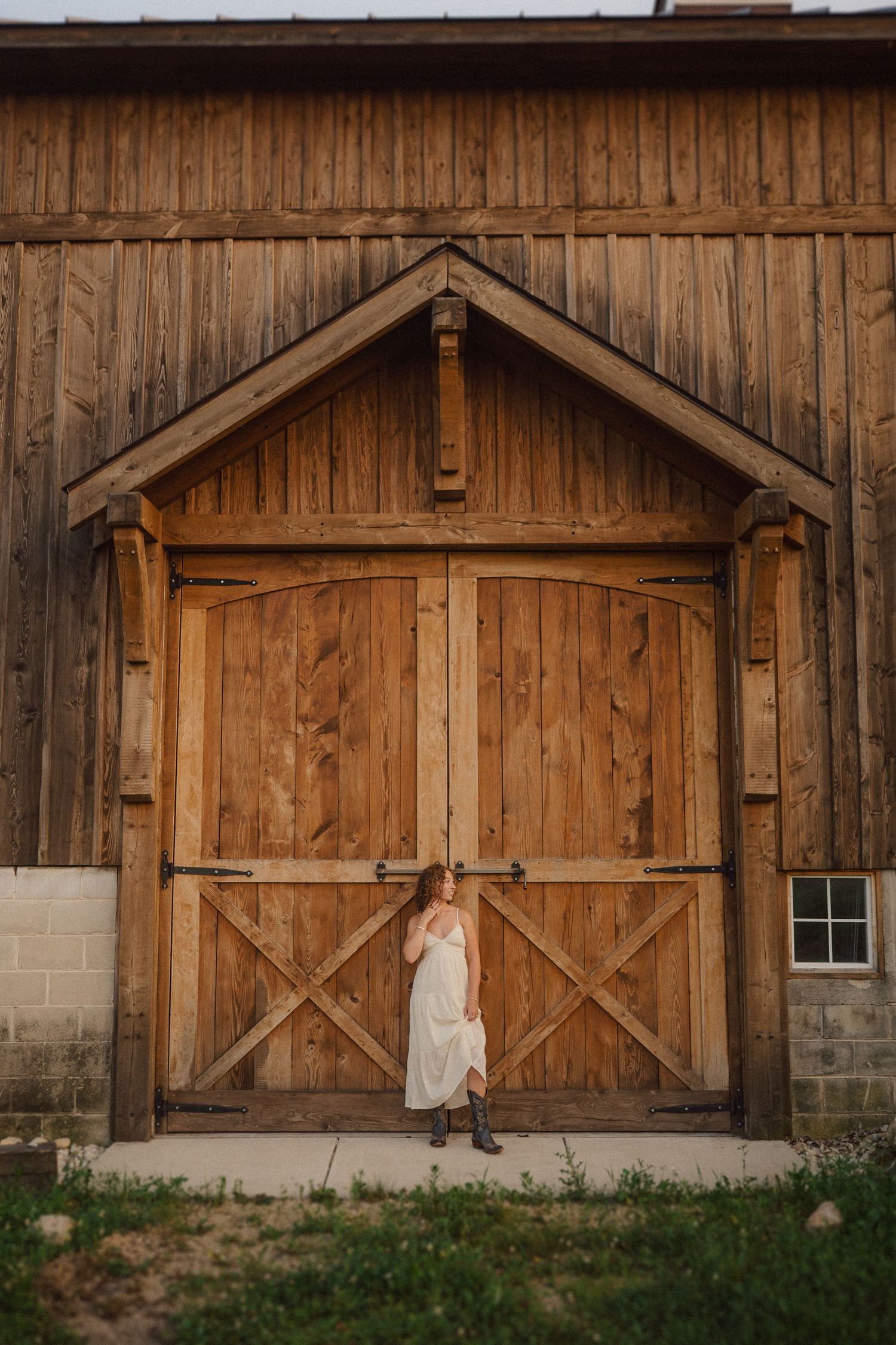 Large wooden barn doors on a rustic structure with weathered siding at sunset.