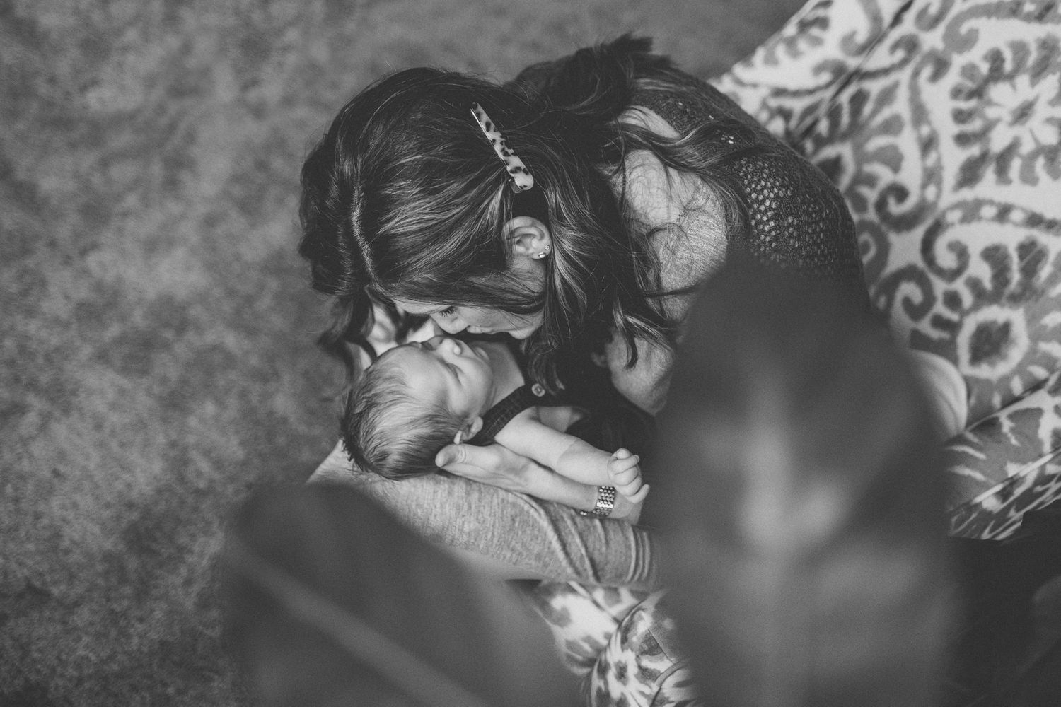 A serene black and white photograph captures a gentle embrace between family members.