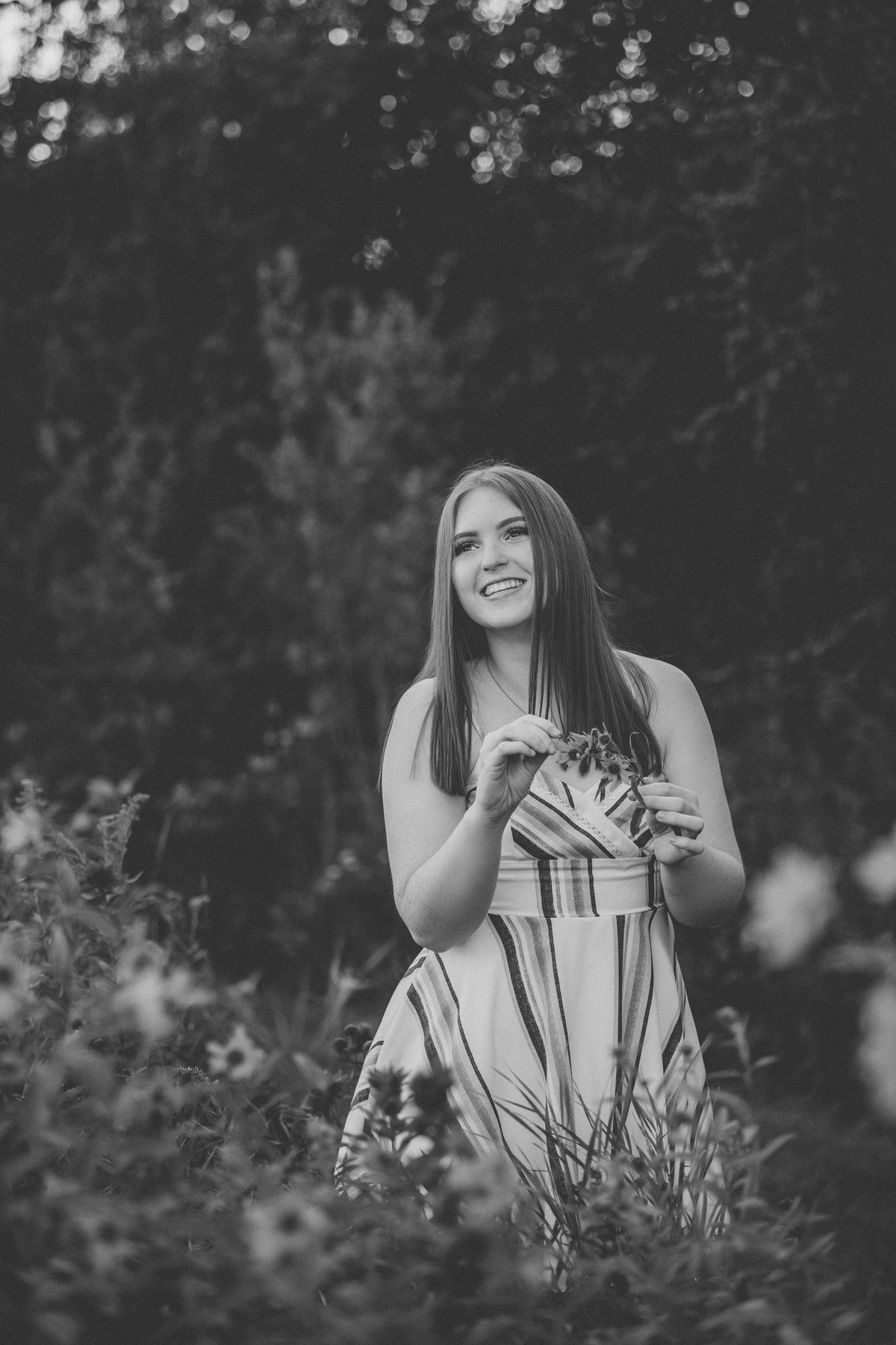 A black and white outdoor portrait showing joy and laughter among wildflowers.