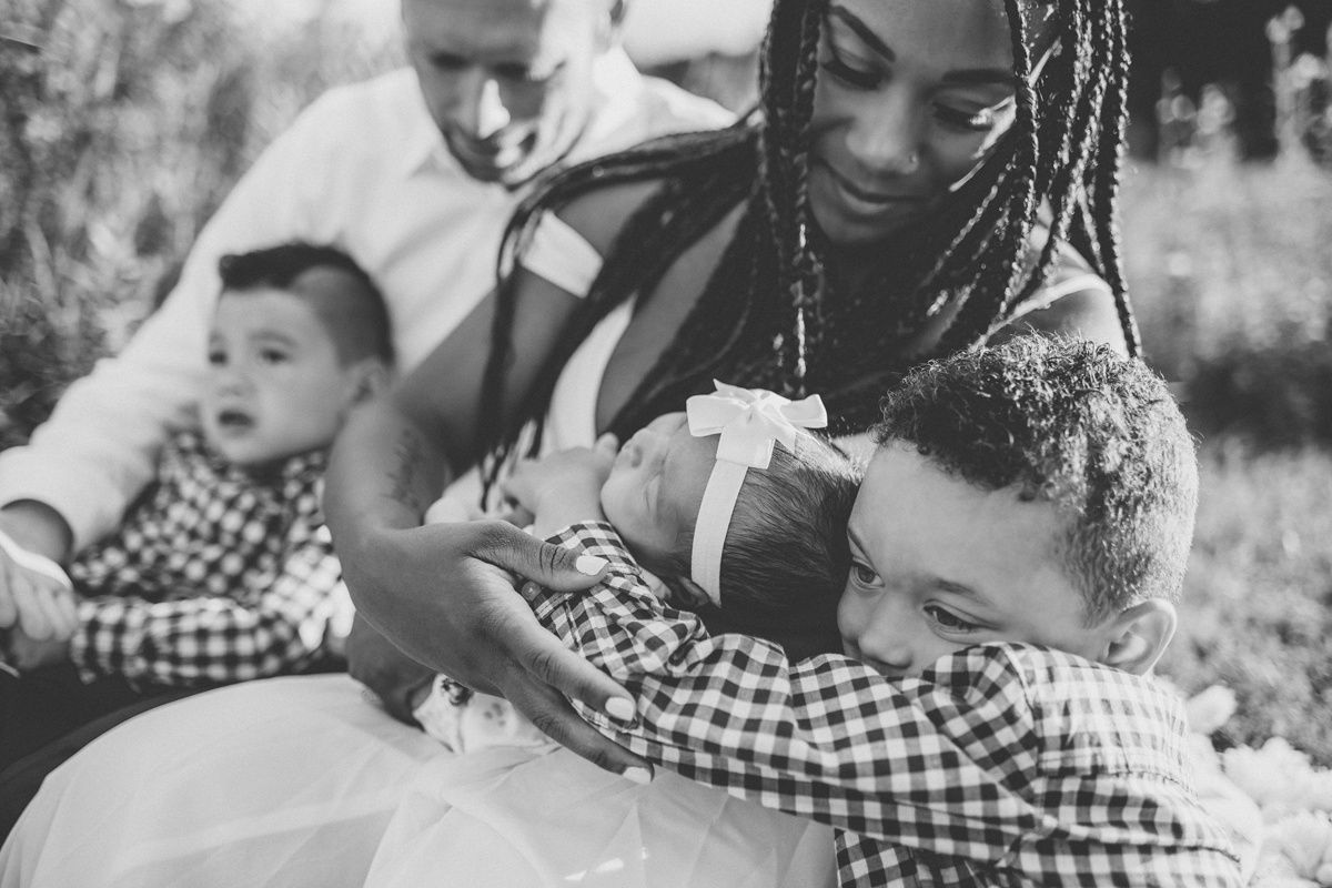 Black and white portrait of a family sharing an intimate moment with their children.