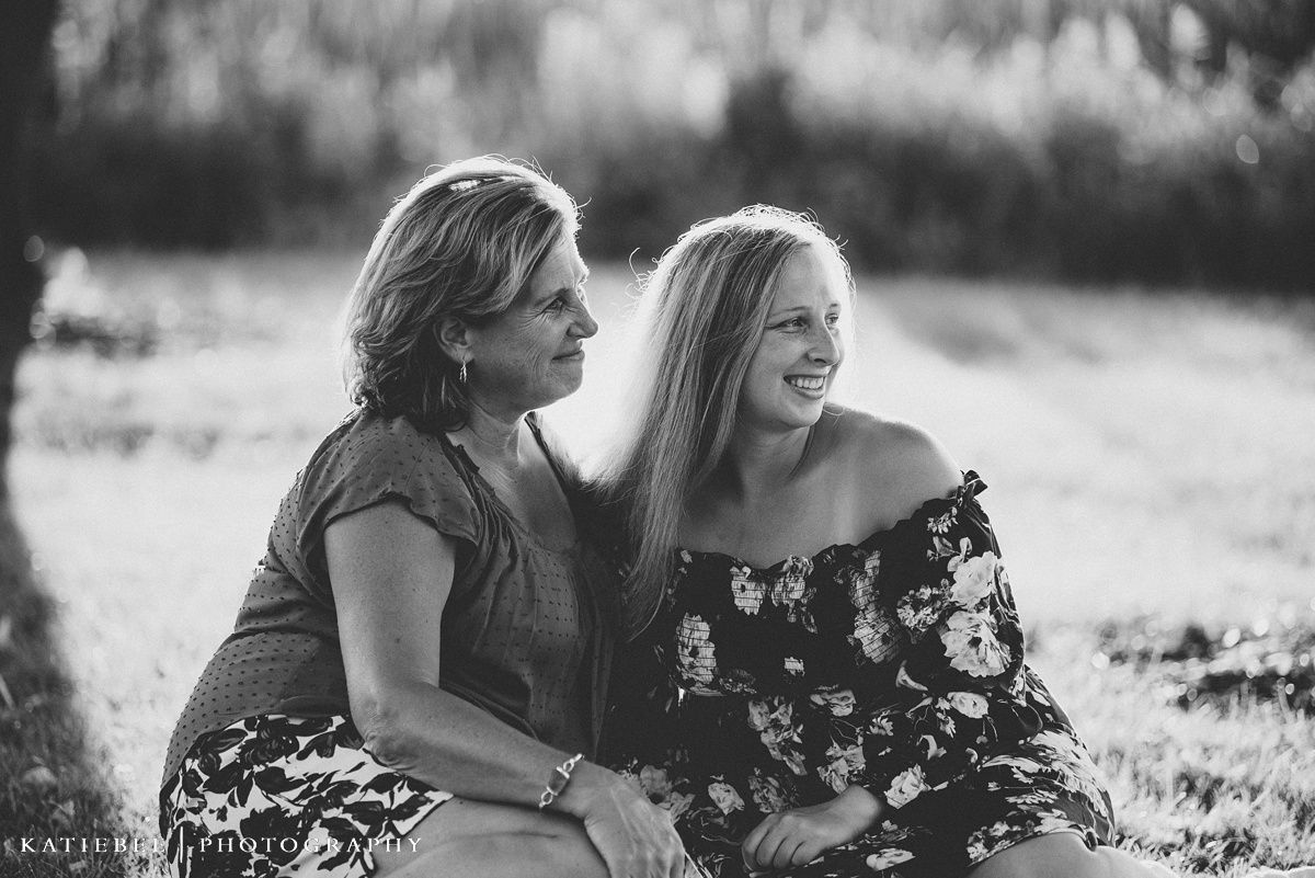 Two people sharing a joyful laugh together outdoors in black and white.