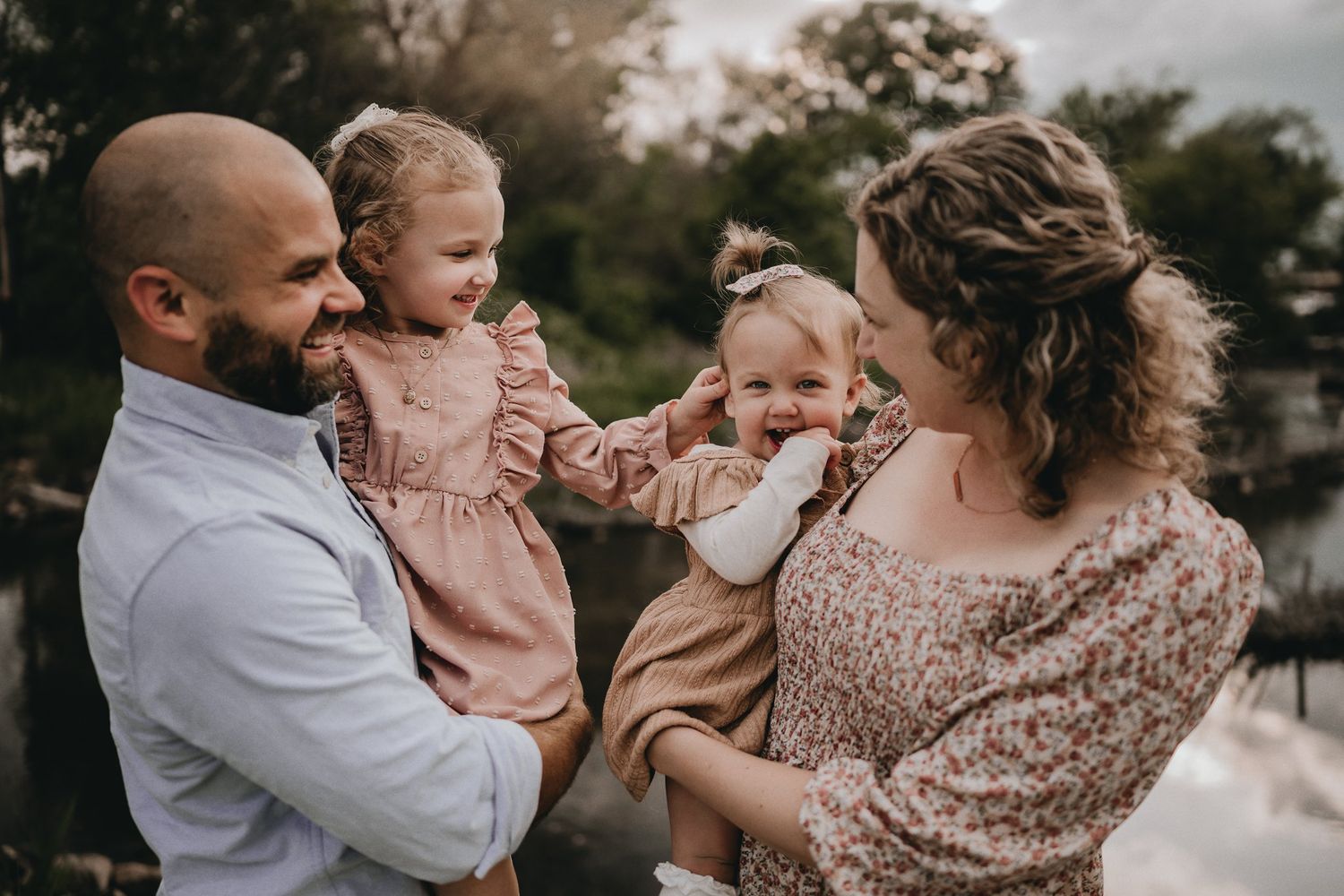 An intimate family portrait captured during a tender moment by the water.