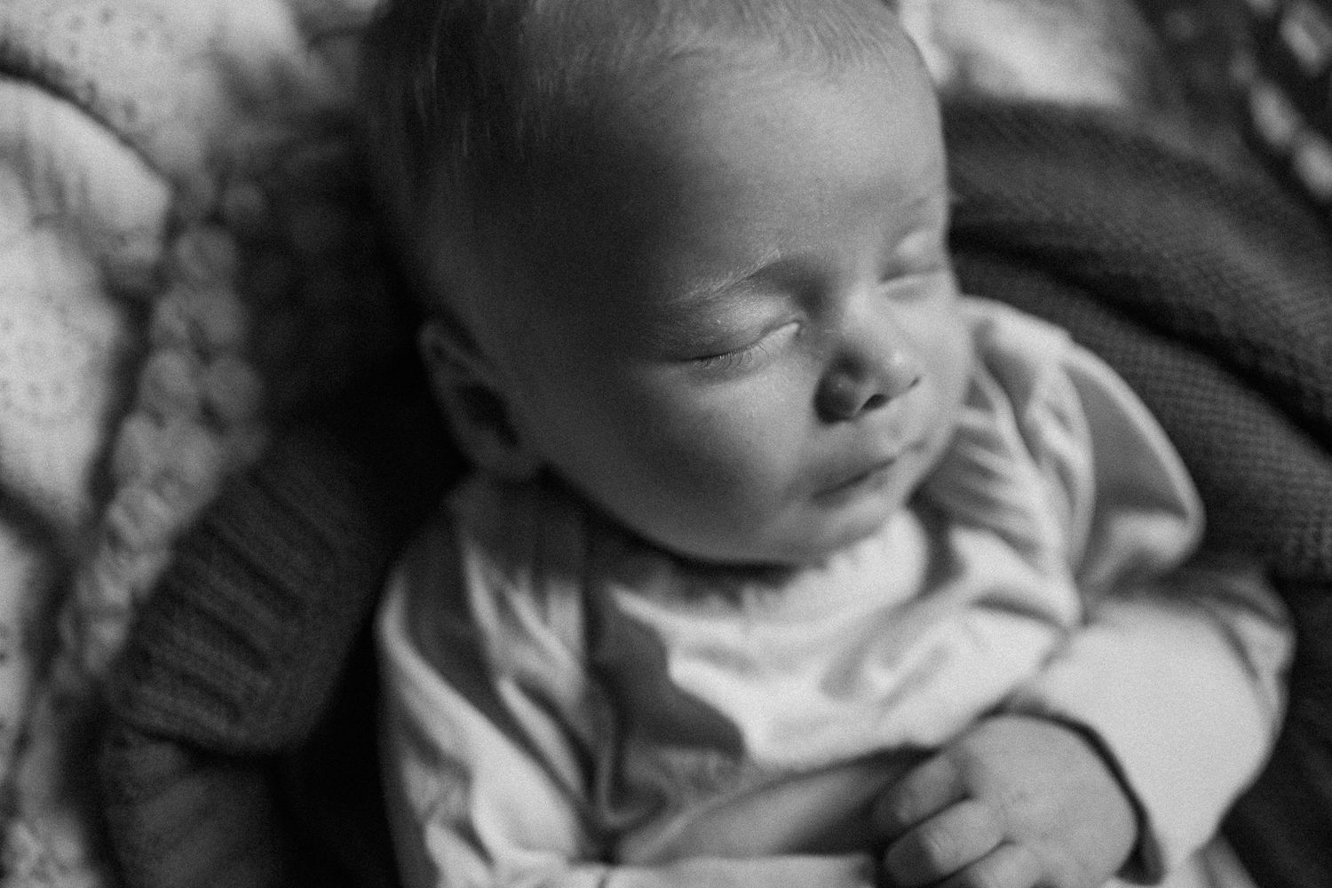 Black and white close-up of a sleeping infant with peaceful expression.