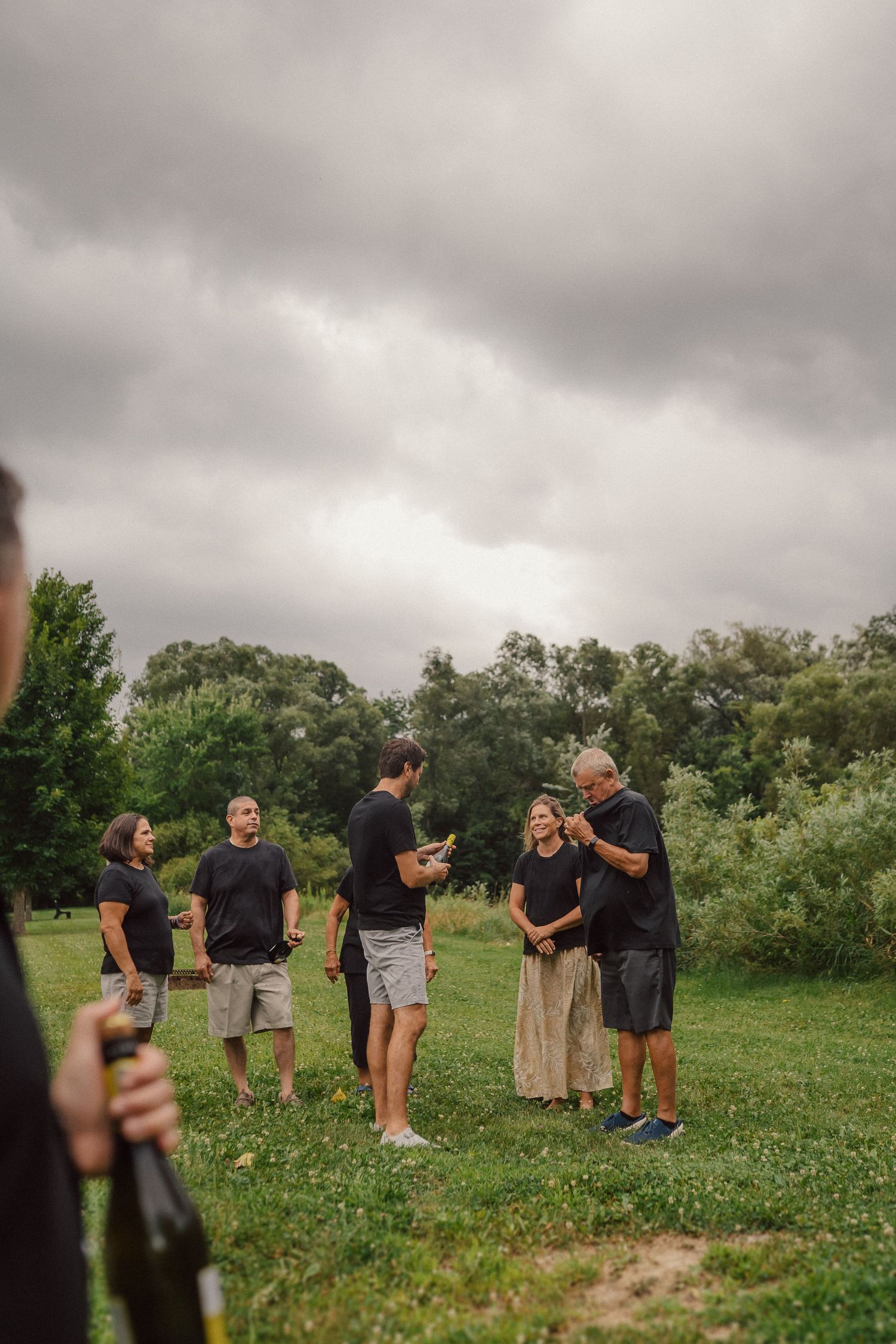 People gathered in casual attire for outdoor activities under cloudy skies.