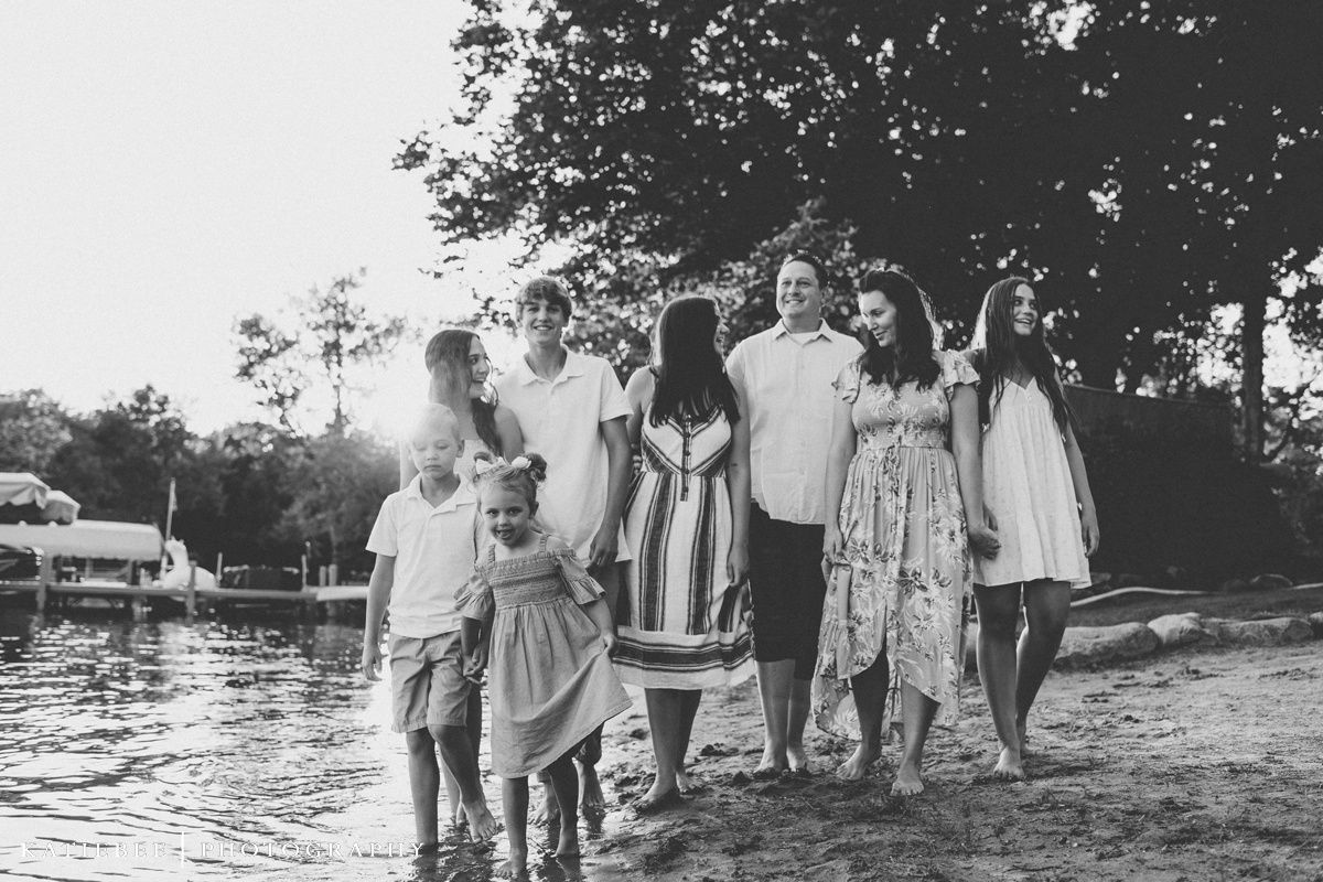 A family group walks along the waterfront in black and white.