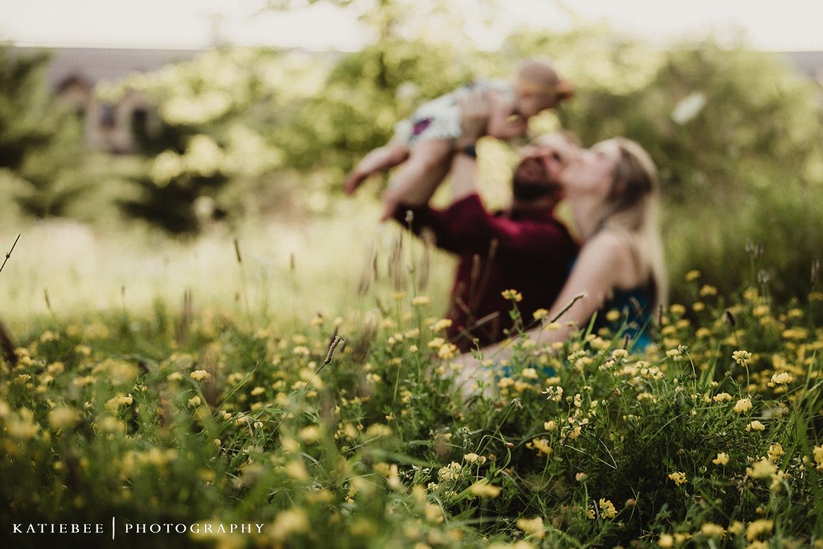 Dreamy bokeh photograph of a family moment in a wildflower field.