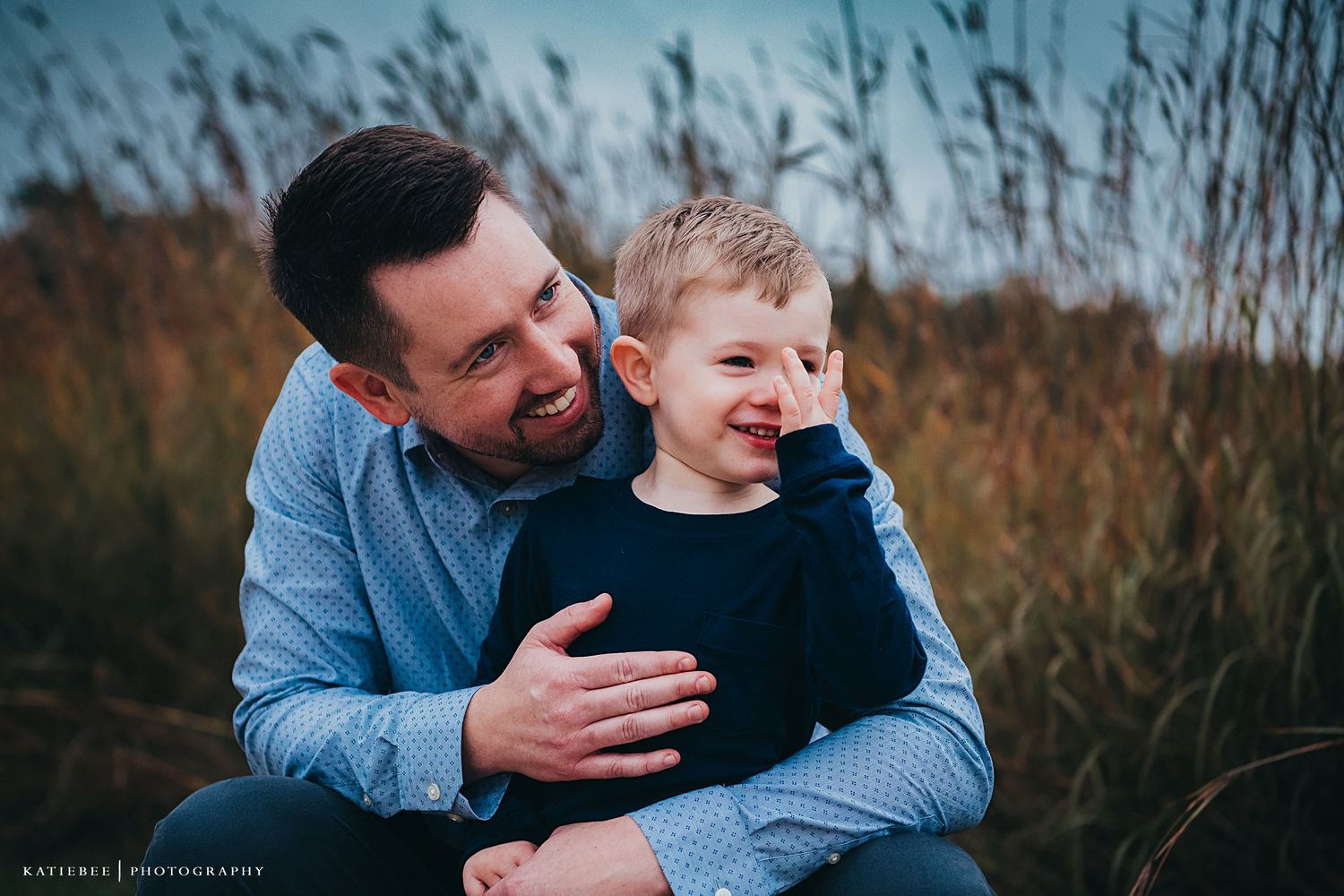 A cheerful moment of laughter captured outdoors against tall grass.