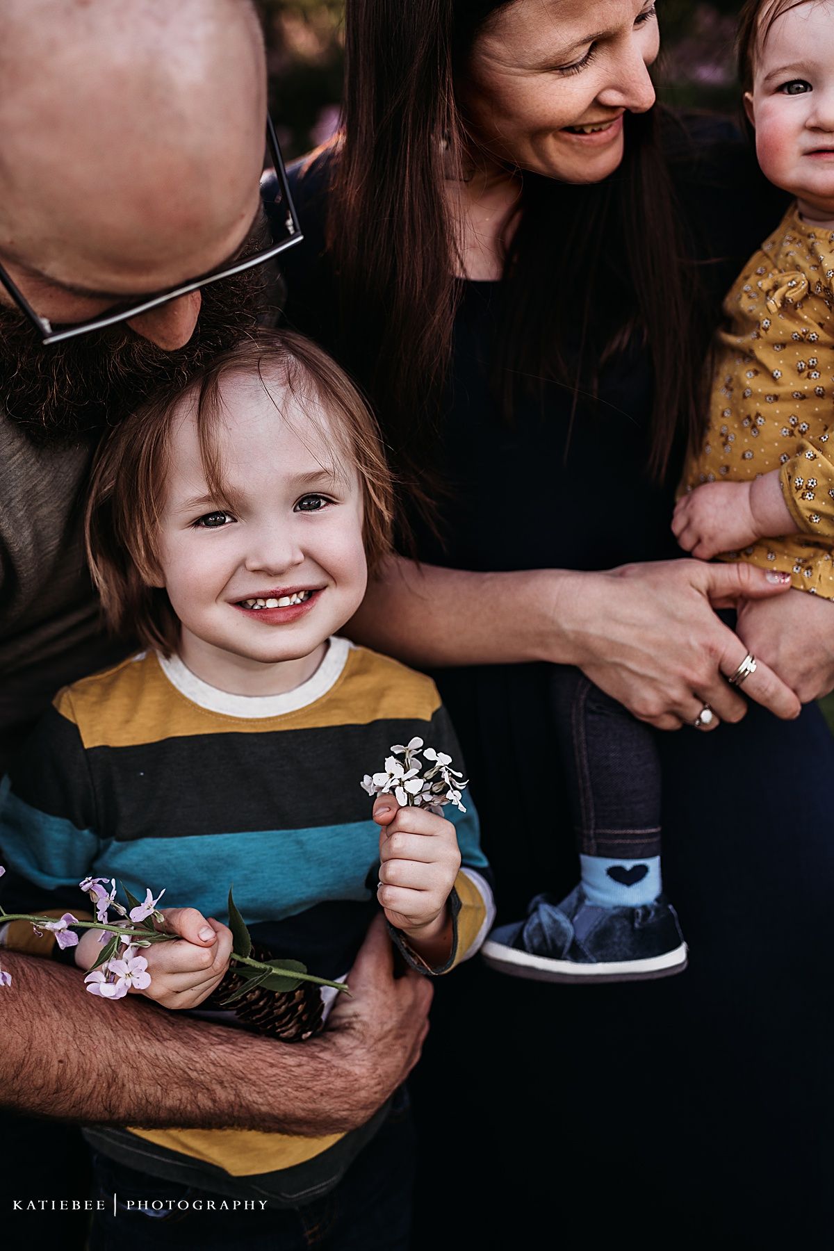 Intimate family moment captured with delicate wildflowers and natural expressions.