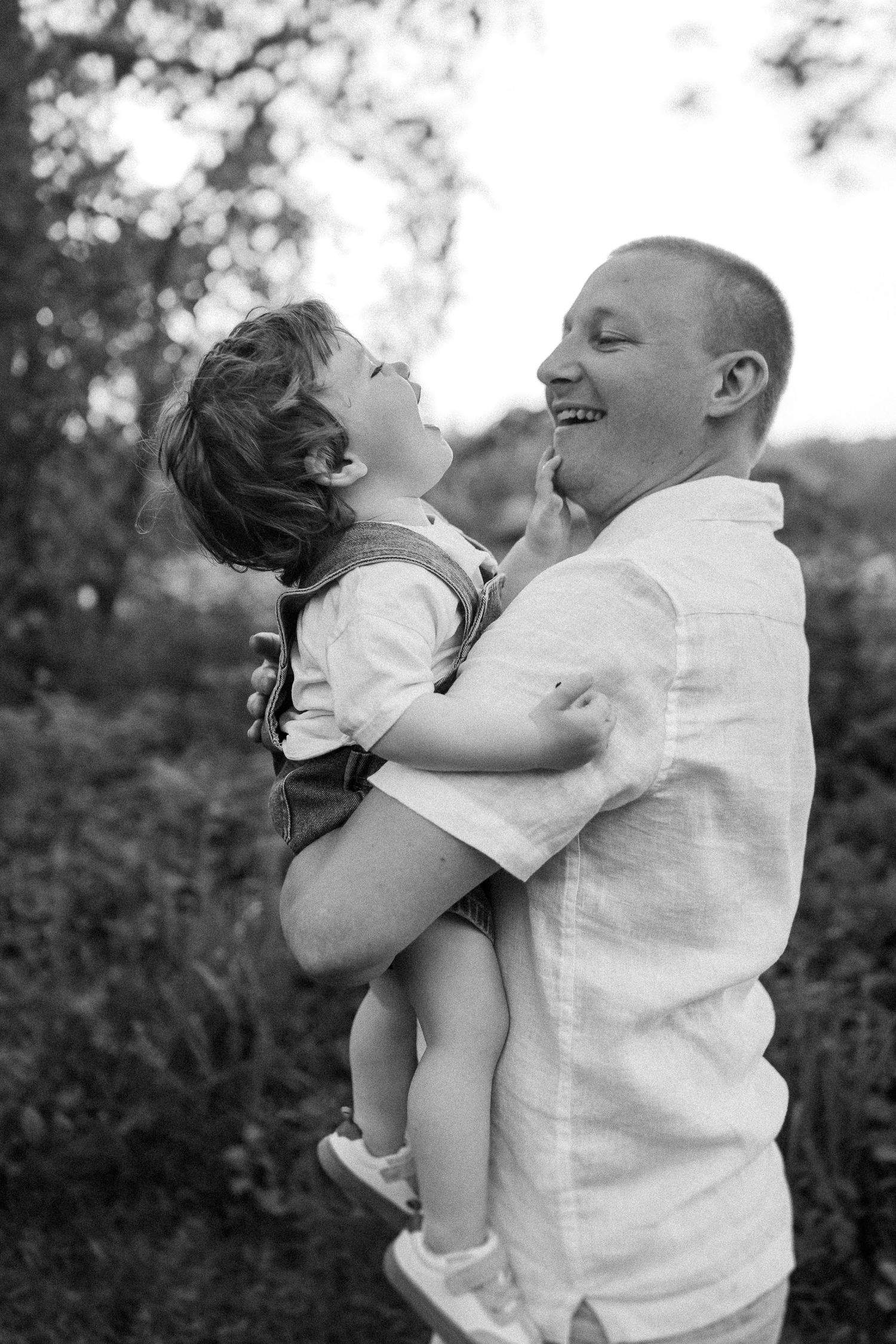 Playful black and white portrait sequence showing joyful interaction between parent and child.