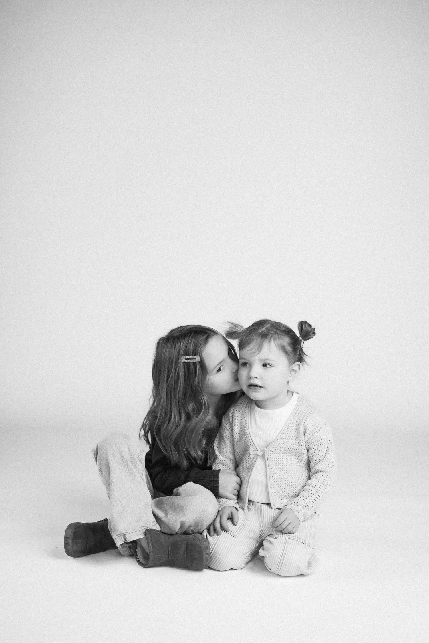 Black and white artistic portrait series showing tender moments against white background.